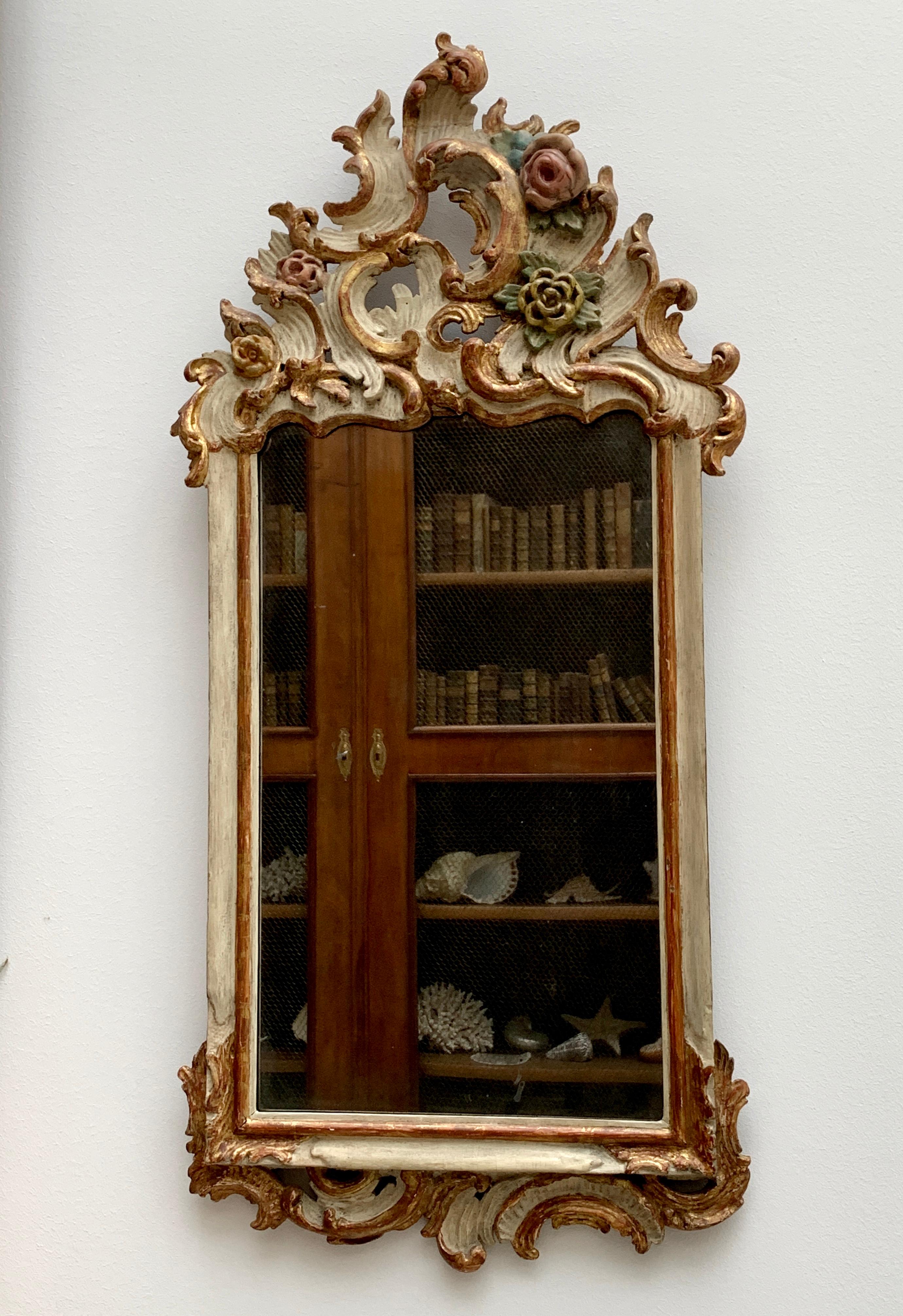 Very charming German 18th century period Rococo mirror. Beautifully carved with c-scrolls and flower buds, white and polychrome painted. Antique mirror plate and orginal back.