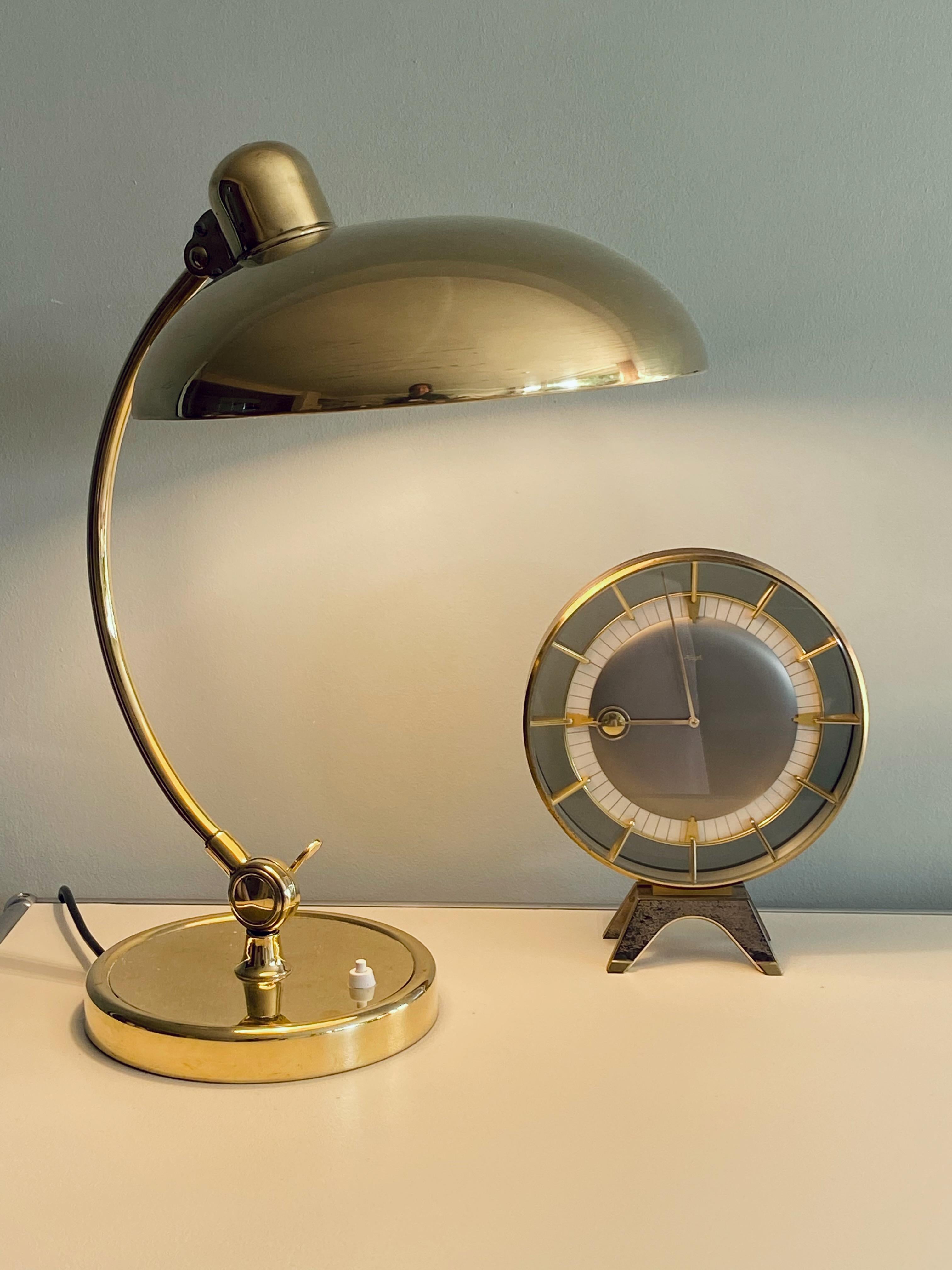Table clock Design by Heinrich Möller in 1950's. Brass metal case, with brass handle and colored glas. Mechanical 8 days movement is working. No damages and nice vintage condition.


