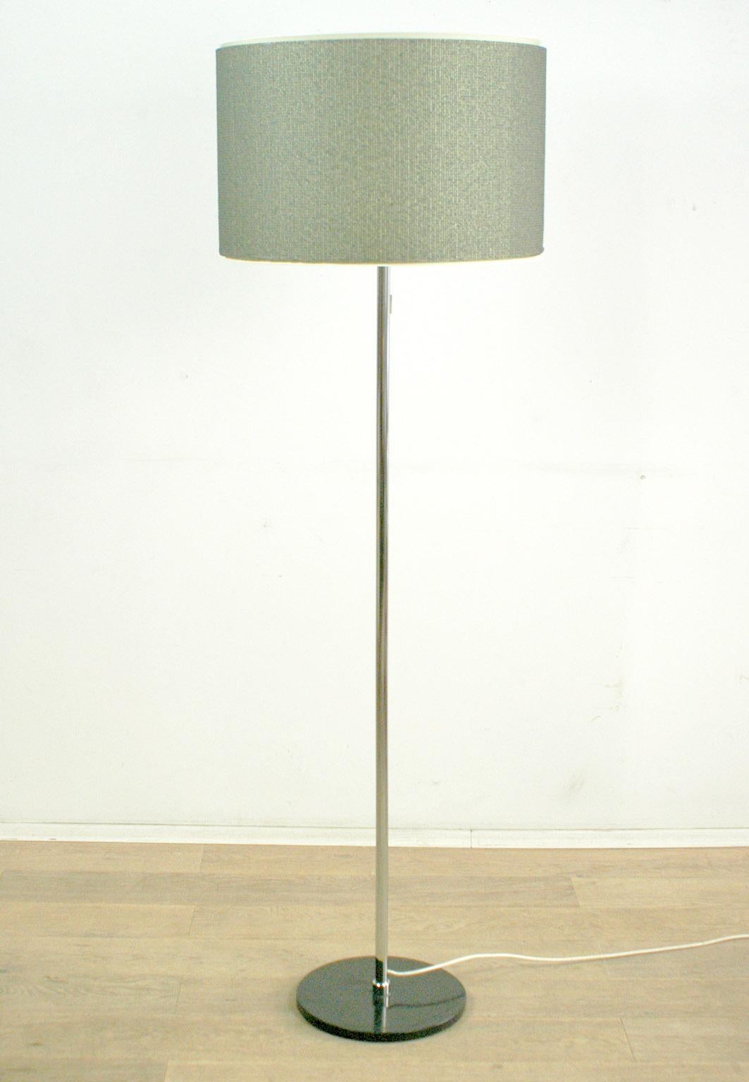 Charming 1960s floor lamp in classical shape with black lacquered metal base and chrome stem, original grey shade.
The light can be switched on separately in upper, middle or lower section of the shade, which gives great and different light