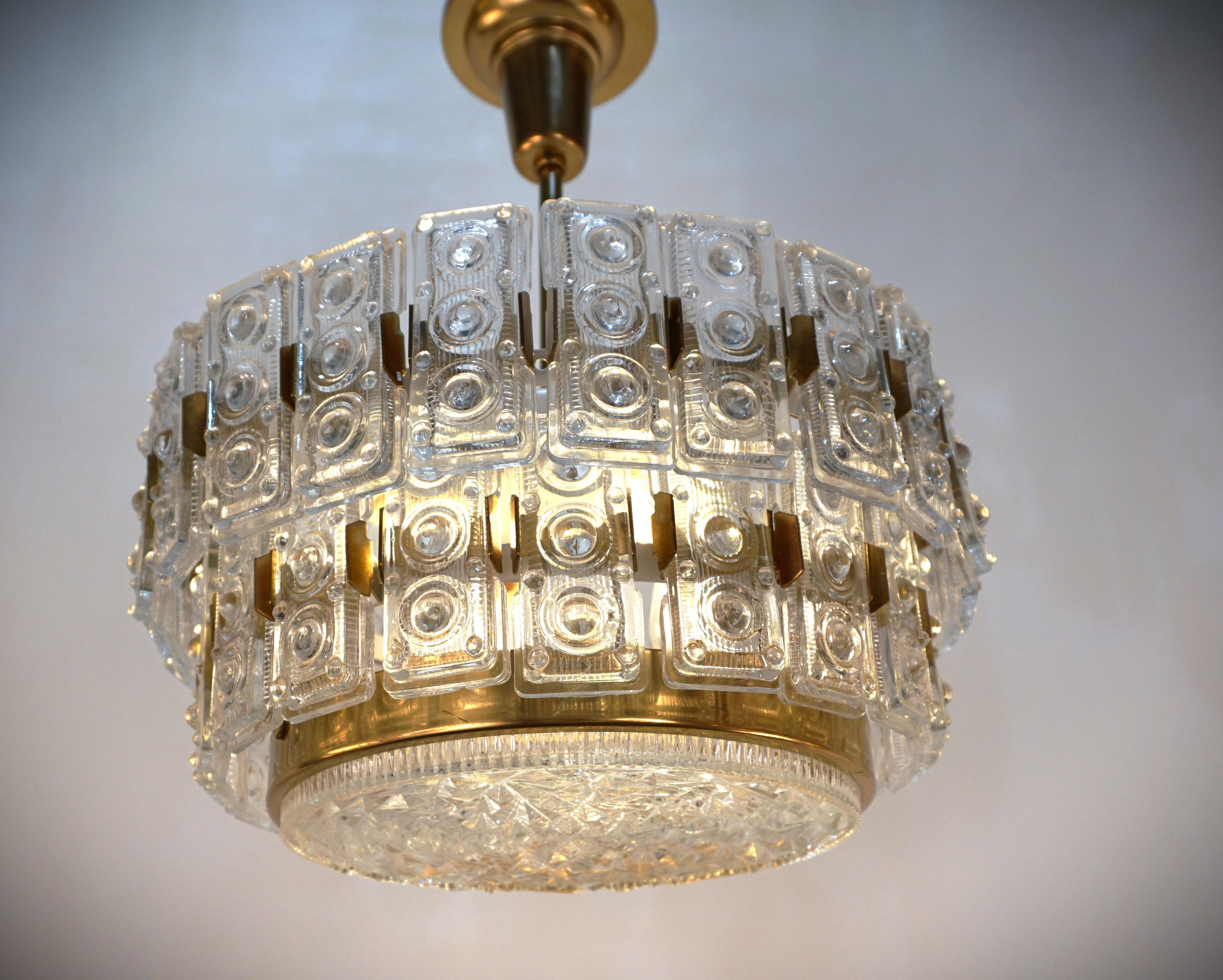 A fantastic design many oblong prismatic glasses surrounding the chandelier with texture center lower glass and bronze frame 1970's chandelier.
Professionally rewired and ready for installation.