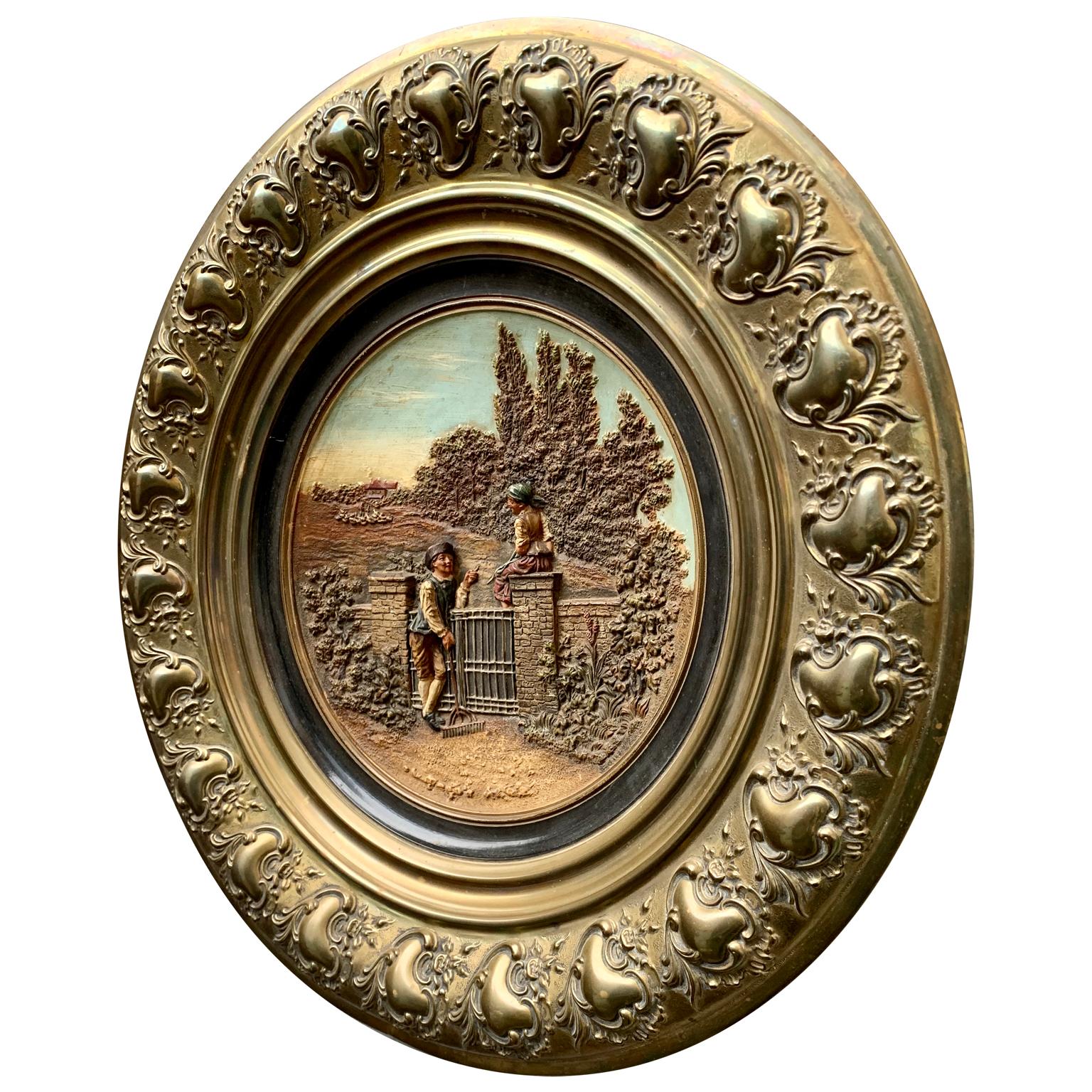 A German 19th century earthenware and brass wall mounted decorative charger. With hand cold-painted polychrome decoration and representing a couple flirting in the country side.