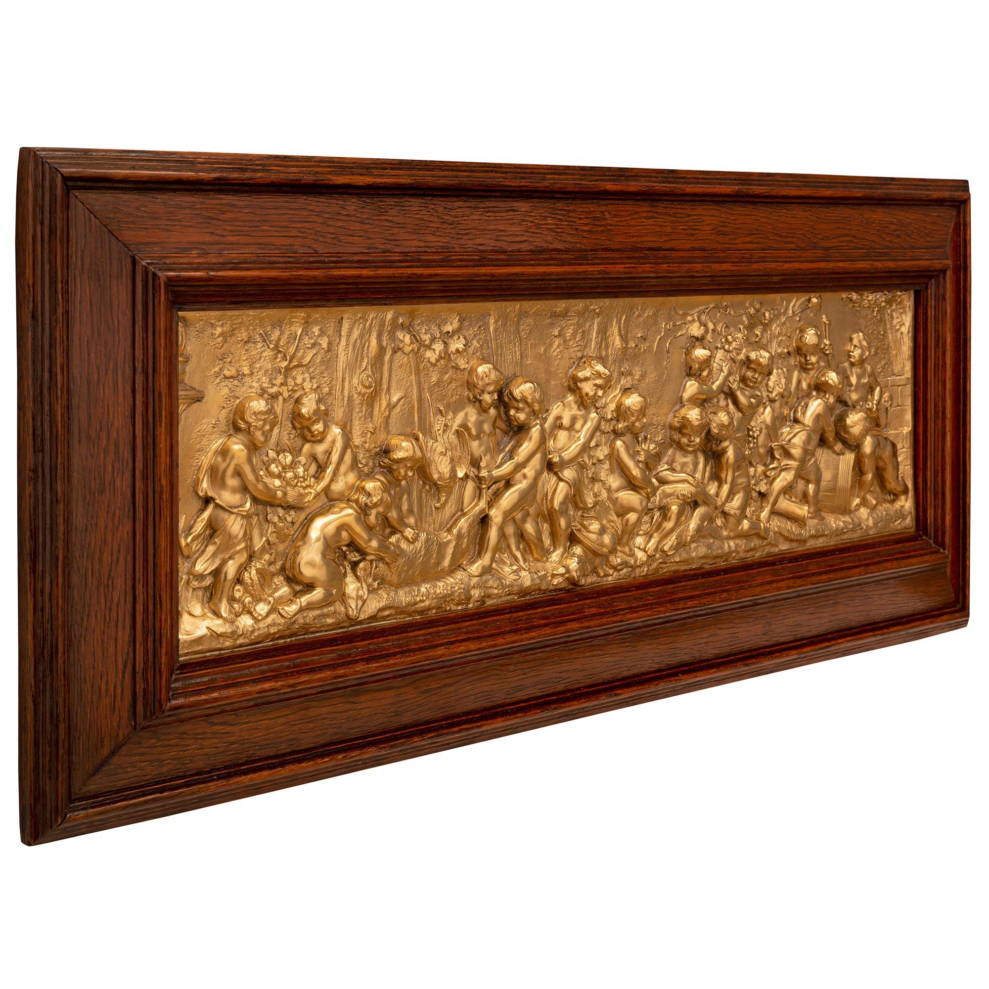 A stunning and most decorative German 19th century Louis XVI st. ormolu and Oak wall decor plaque signed Gustav Grohe. The wonderfully executed and exquisitely detailed ormolu plaque depicts charming Bacchanalian cherubs preparing the spoils of