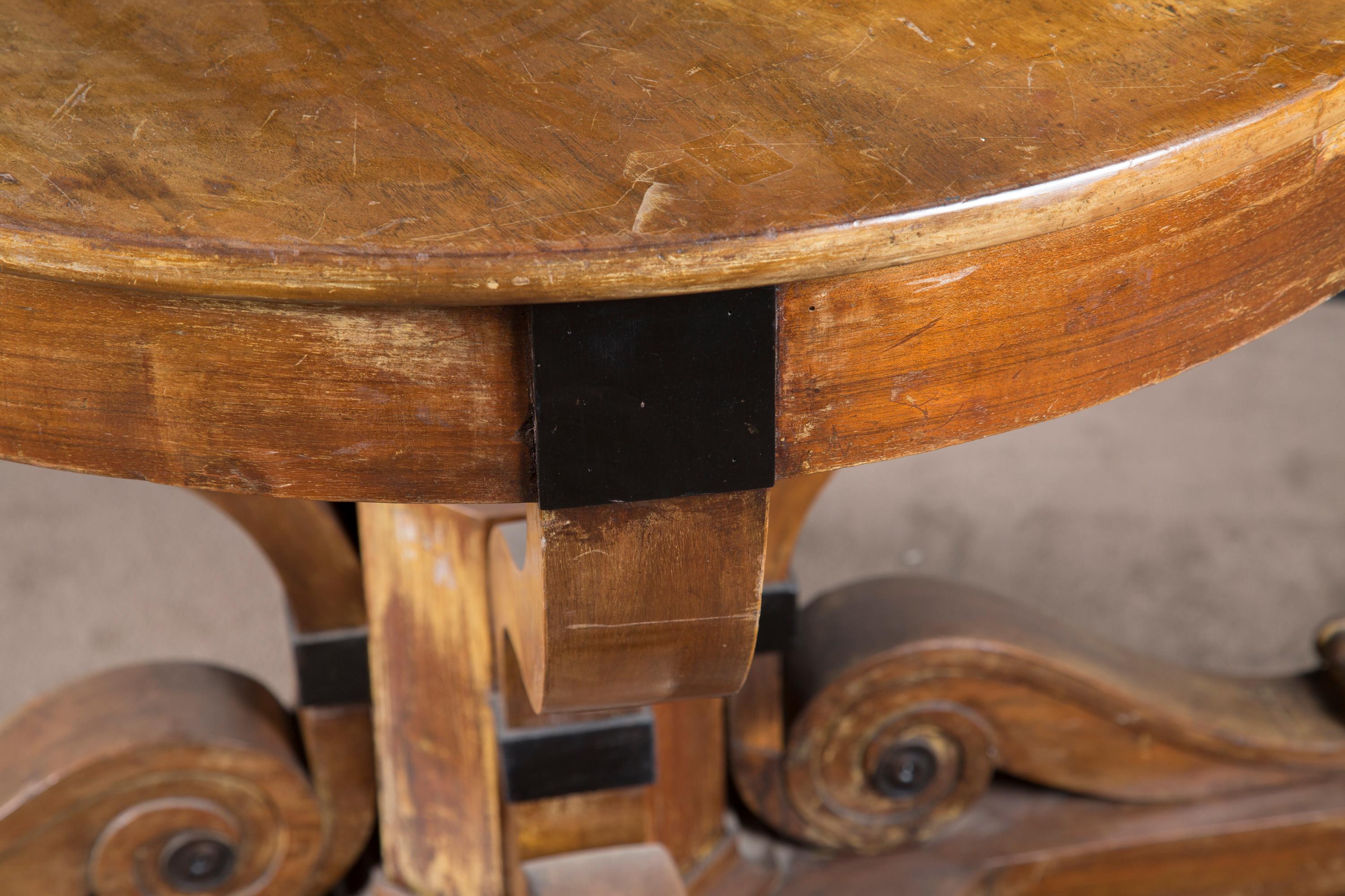 Fantastic period round Biedermeier pedestal table made of ebony and walnut. The German antique piece dates back to the early 19th century, circa 1820, and perfectly exemplifies the style and emotion of the era in which it was created.

This piece is