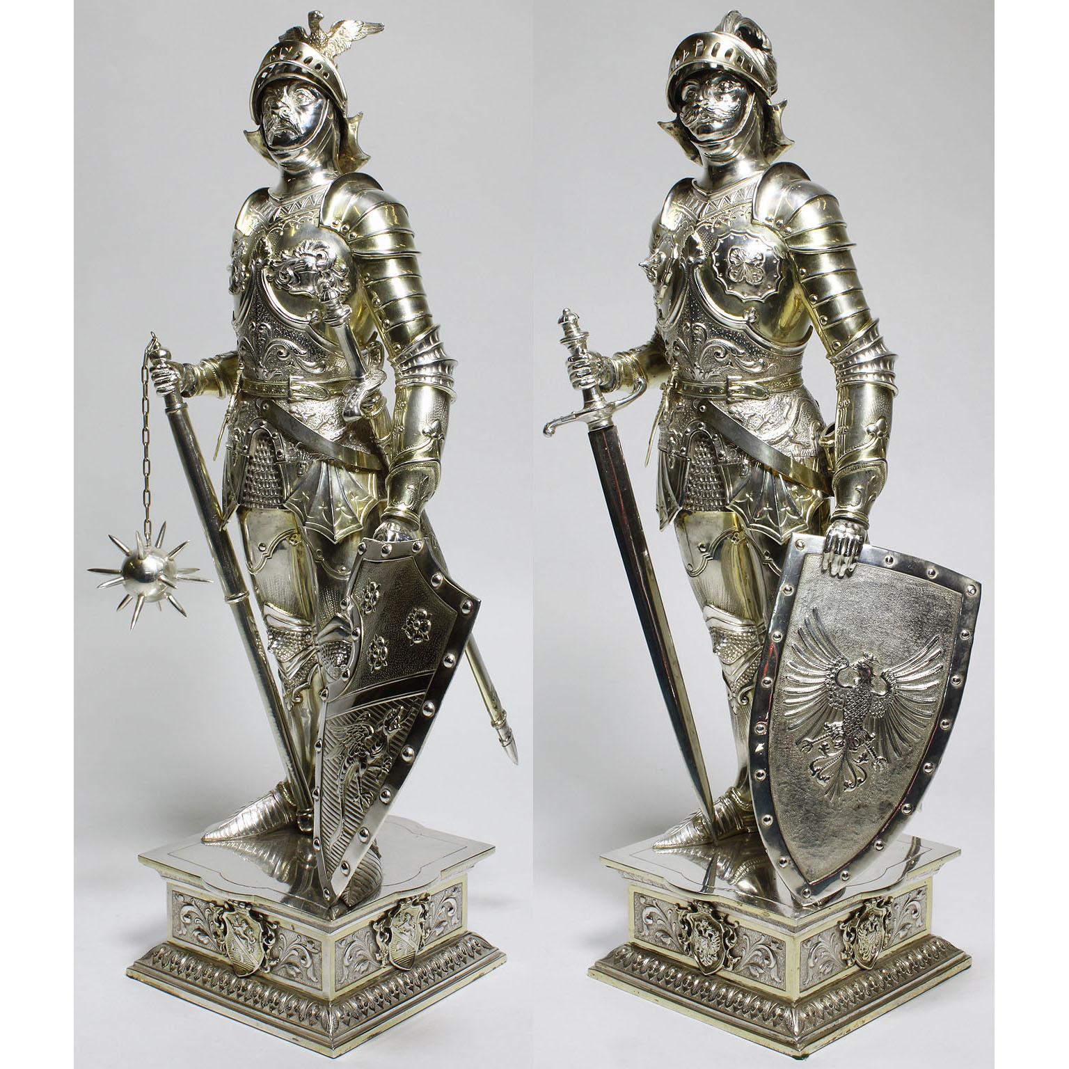 A very fine, large and rare pair of German 19th century silver and vermeil silver standing models of medieval knights in full armour, applied to each side with a shield engraved with a coat-of-armour and movable visors, one knight sporting a