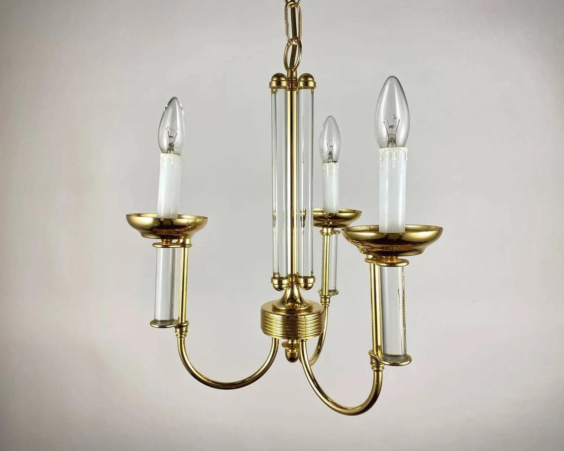 Very pretty mid 20th century German chandelier made of gilded brass with three arms supporting faux candles.

Circa 1980s.

The chandelier is made of gold-colored brass, has a suspension to the base on a chain.

A stylish ceiling lamp will