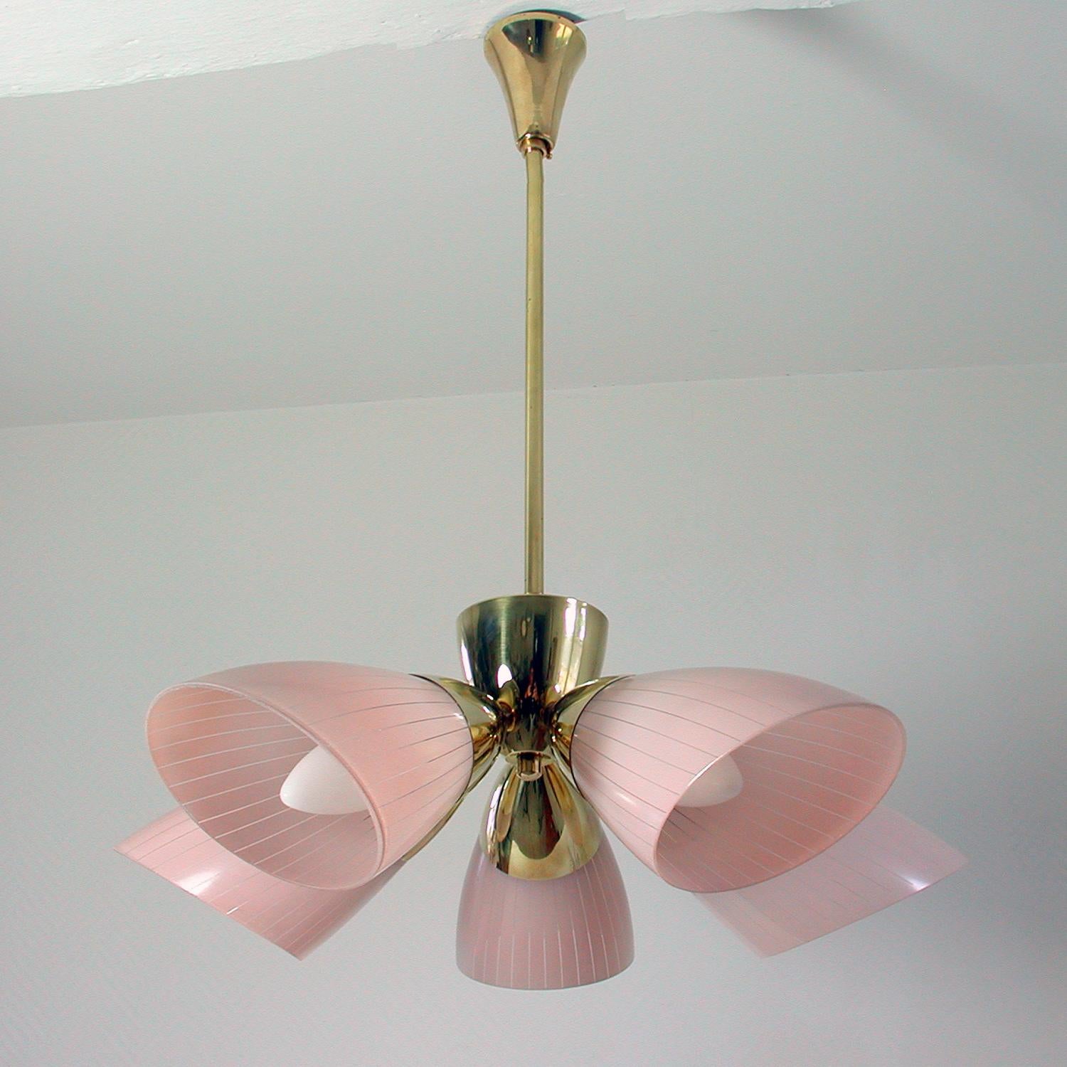 This elegant Sputnik style chandelier was manufactured in Germany in the 1950s. It is made of brass and has got 5 pale pink glass lamp shades.

The brass lamp rod (drop) can be shortened or removed on request. When removed the chandelier can be