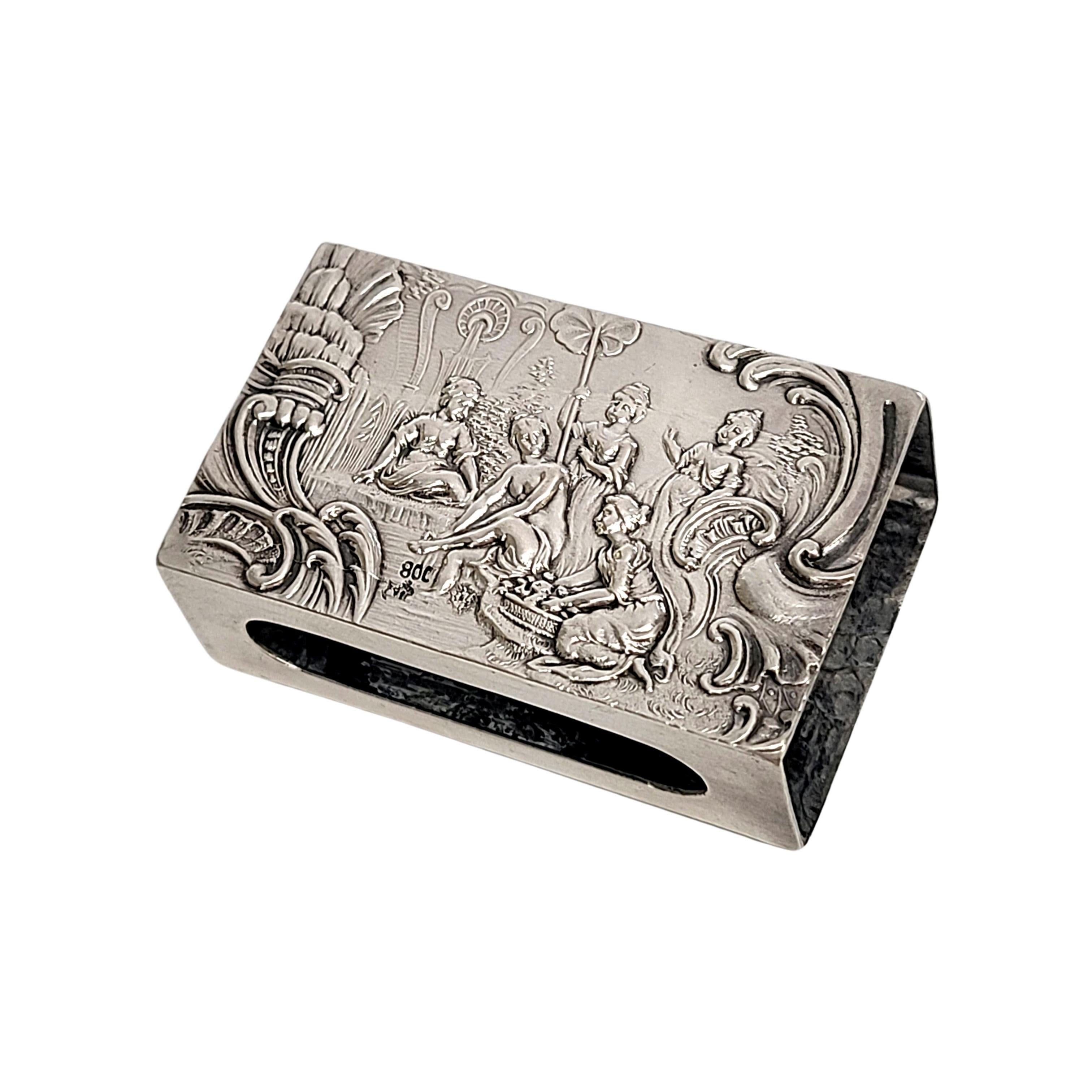 German 800 silver matchbox holder.

No monogram

This sterling silver matchbox holder features a repousse scene on each side. One scene is children frolicking's with a dog. The other scene is a group of women.

Measures 1 7/8