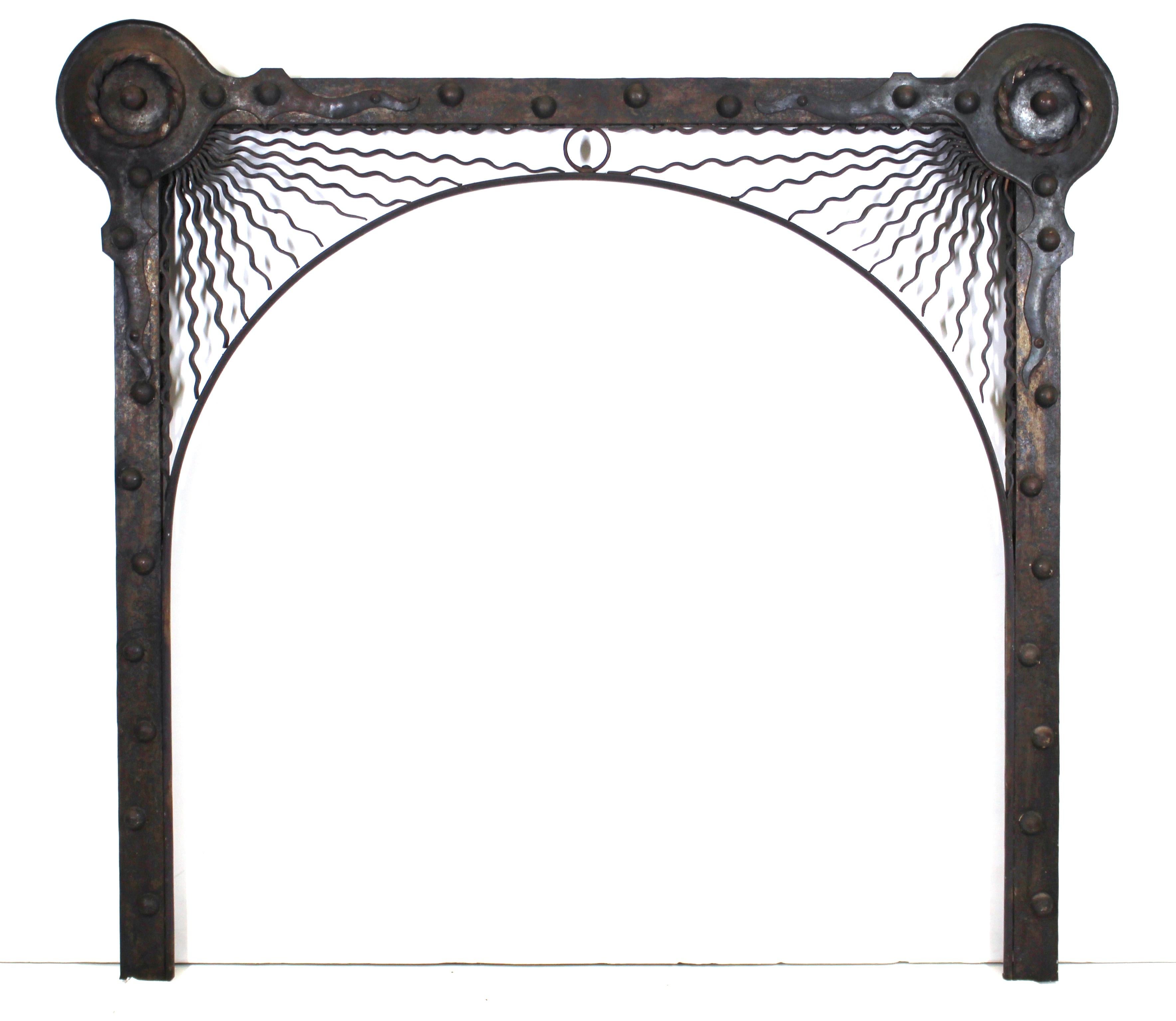 German Aesthetic Movement fireplace surround in handwrought iron. The piece features sunrays on each upper corner emanating from circular discs. Handmade in the 1880s in Germany. In remarkable antique condition with age-appropriate wear and use.