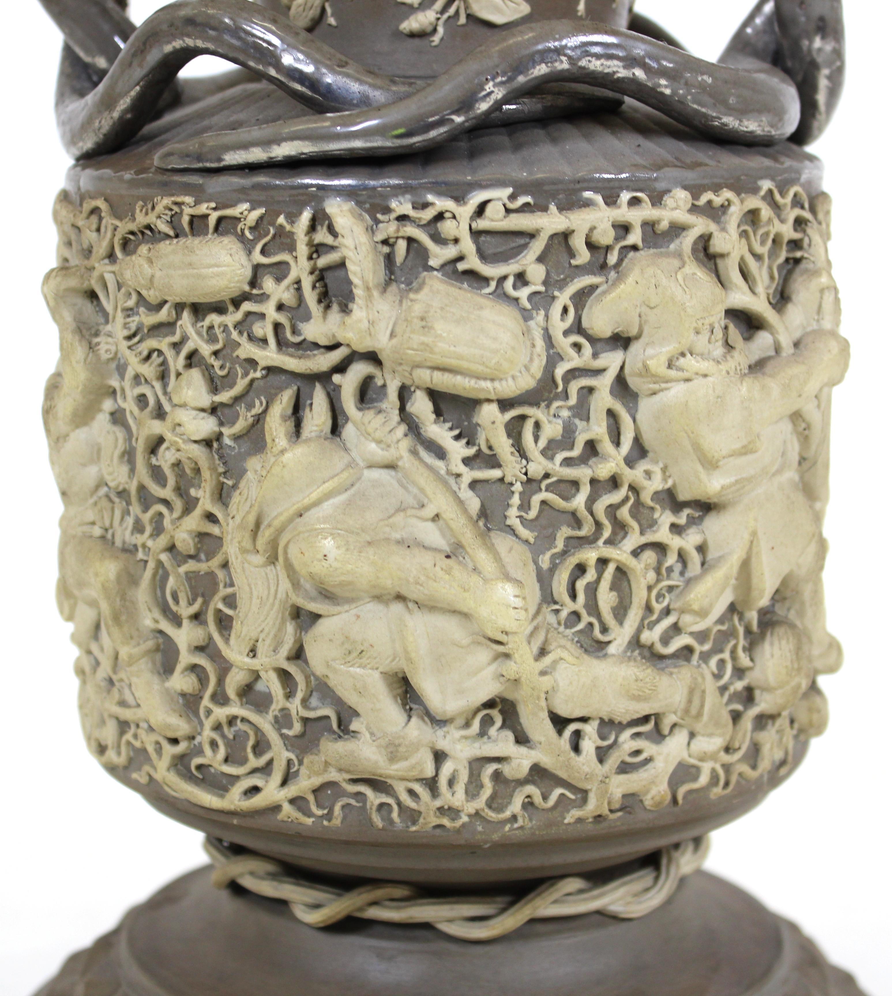 German or English Aesthetic style rare exhibition piece vase, of Mettlach style, in gray clay with applied ornamentation consisting of a large detailed frieze depicting beetles at war with gnomes, applied bees to the neck and silvered snake handles,