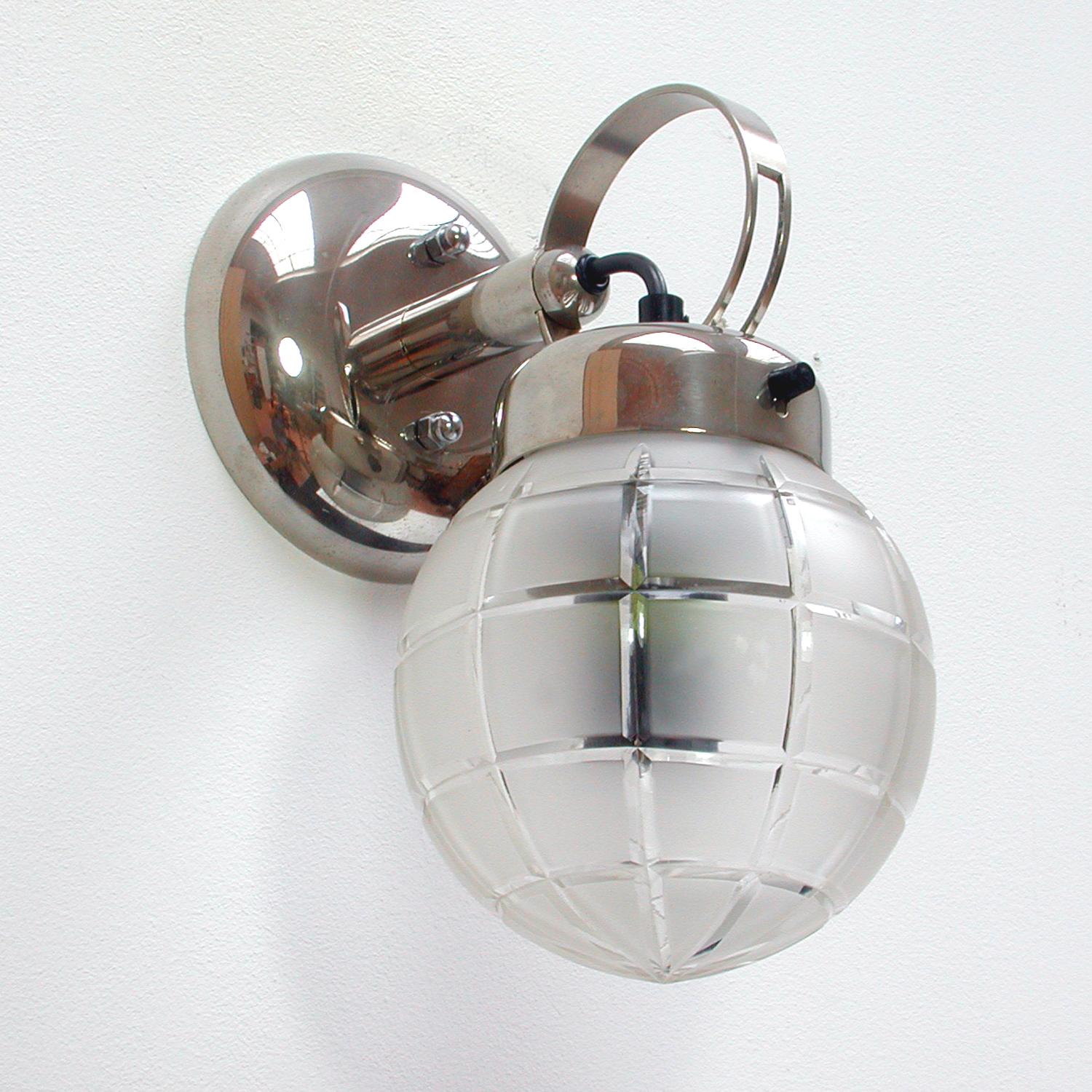 This Bauhaus inspired wall light was designed and manufactured in Germany in the 1930s. It is made of chrome and has got a geometric and partially frosted glass lamp shade. The lamp requires a E27 light bulb and has been rewired for use in any
