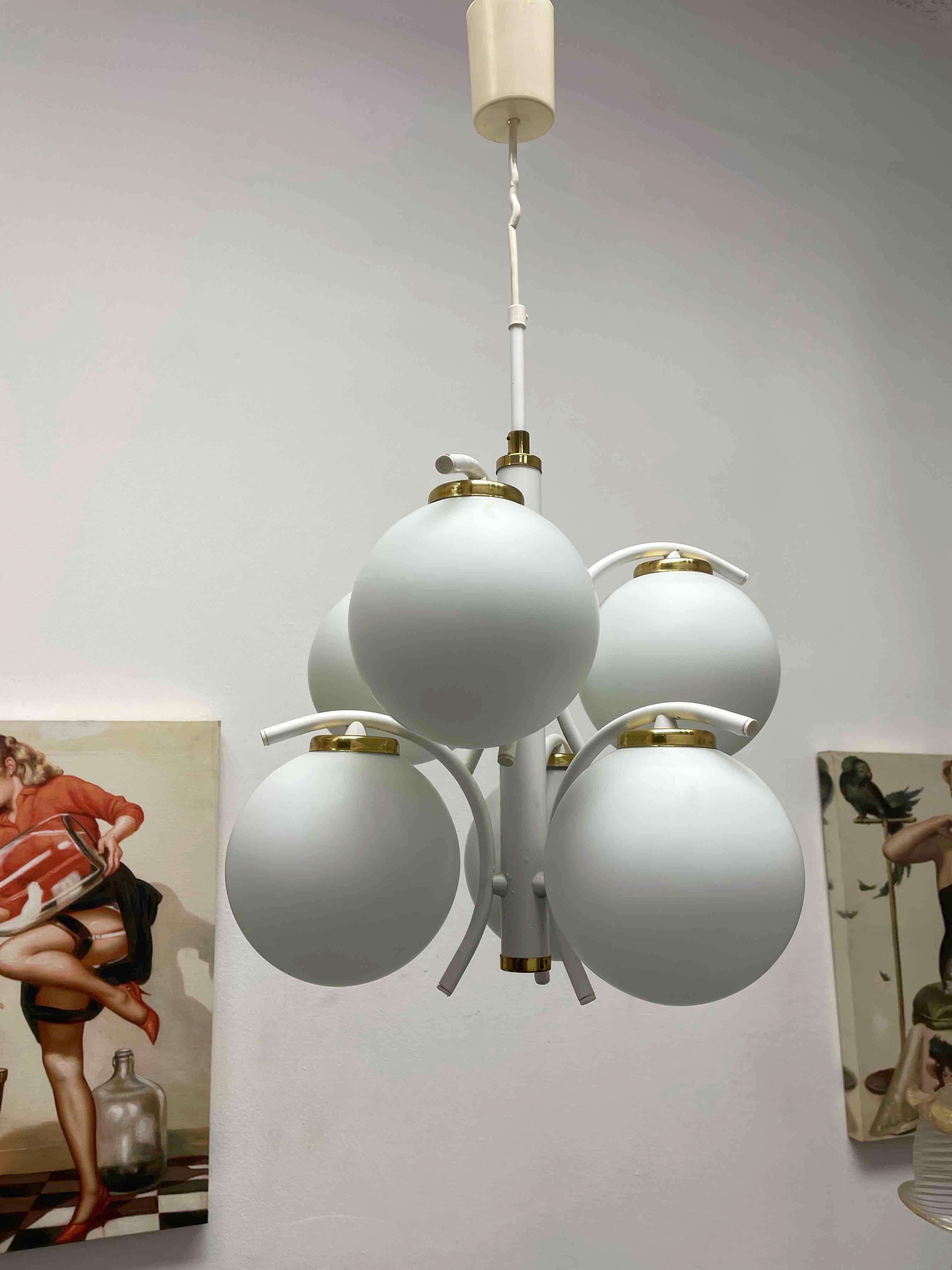 This Art Deco Bauhaus Style chandelier was made in the 1960s in Germany. It is made of six unique glass balls mounted on a white lacquered frame. The fixture requires six European E14 candelabra bulbs, each bulb up to 40 watts. A nice addition to