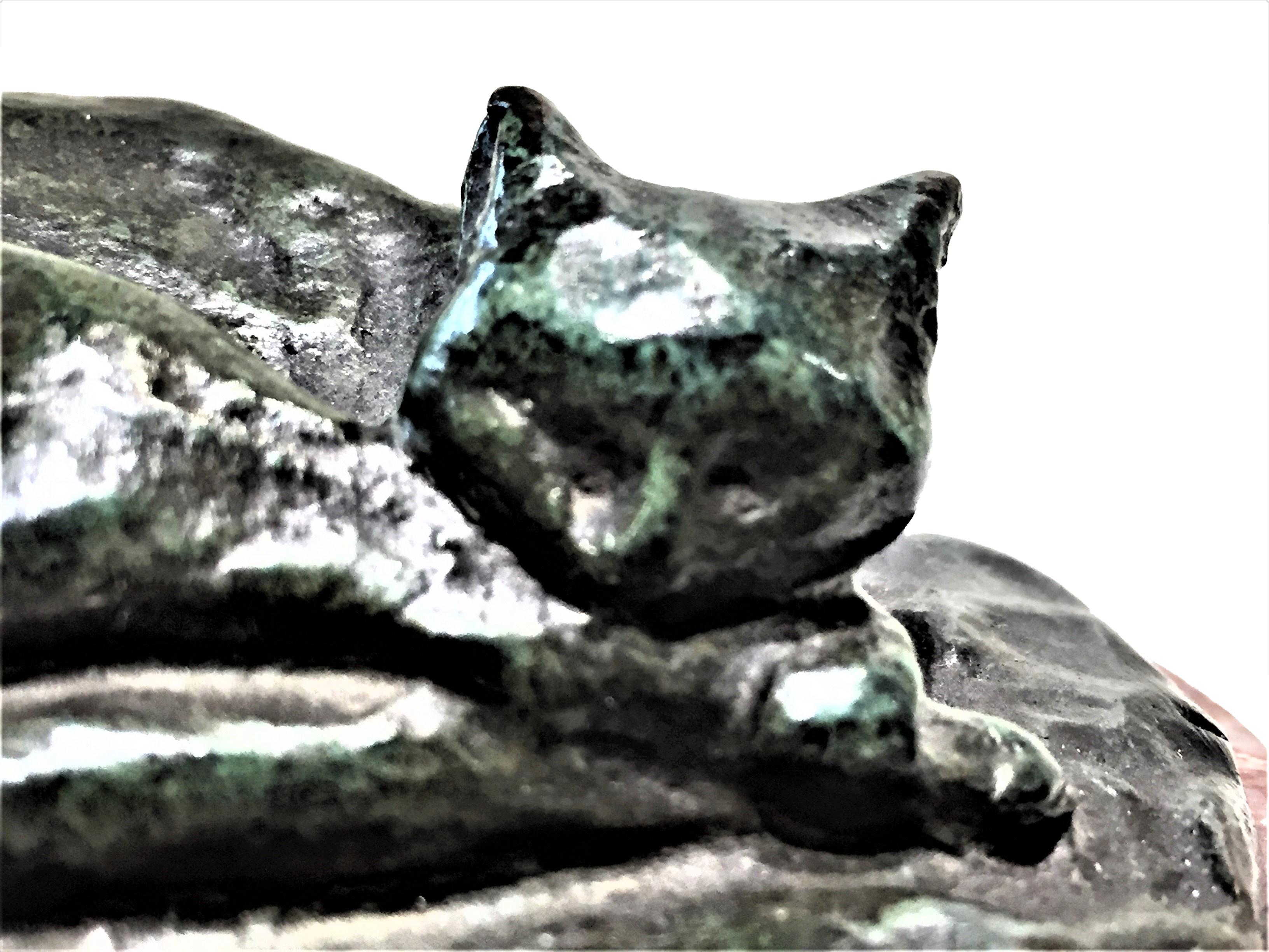Signed with initials “MP.” and marked with three illegible stamps.

Dimensions: 
Height 1-3/4” (4.37cm) width 3-3/4” (9.37cm) depth 3-7/8” (9.7cm)

This charming sculptural paperweight, depicting a sleeping cat of dark-green patinated bronze on
