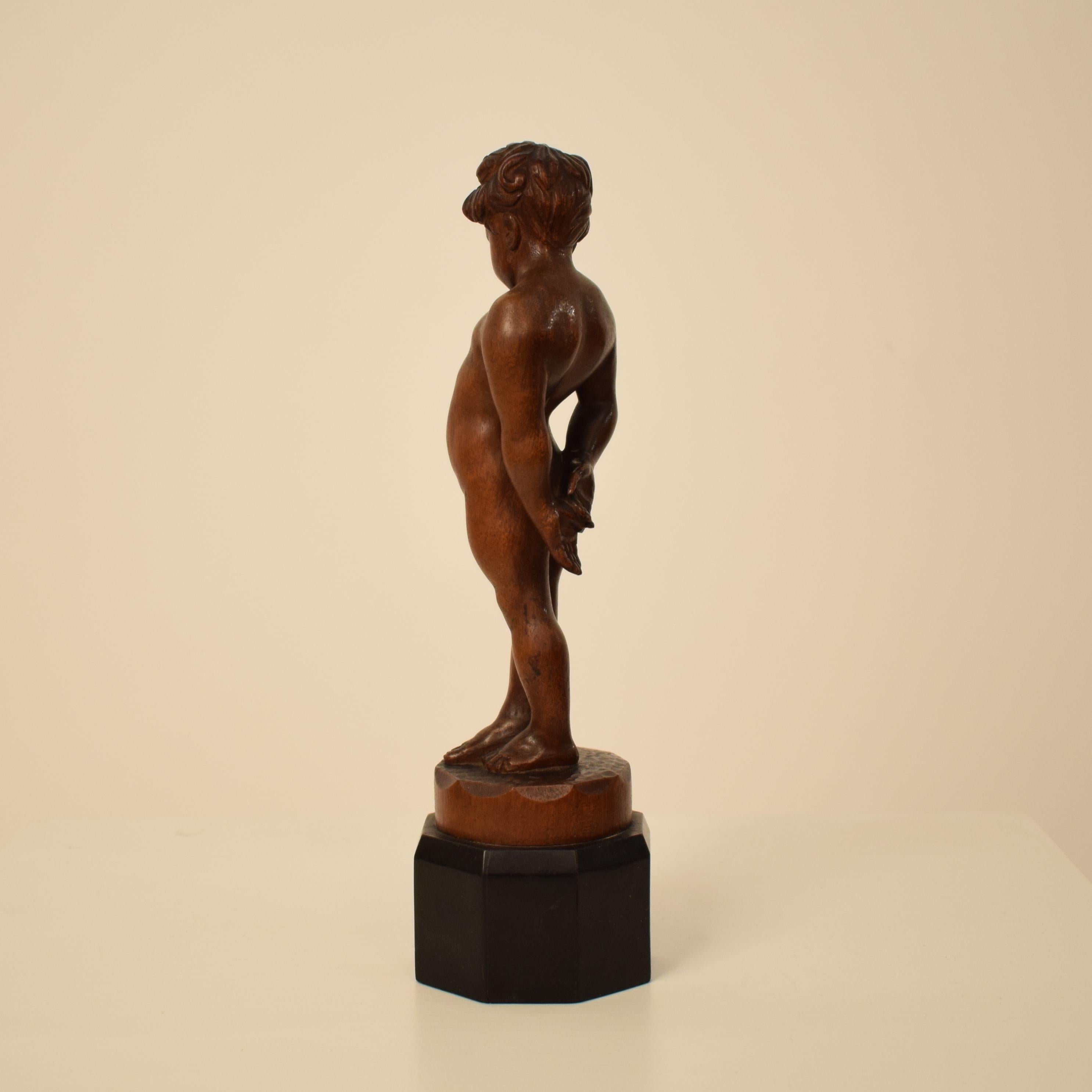 Early 20th Century German Art Deco Carved Wooden Walnut Sculpture of a Boy with Ebonized Base 1927