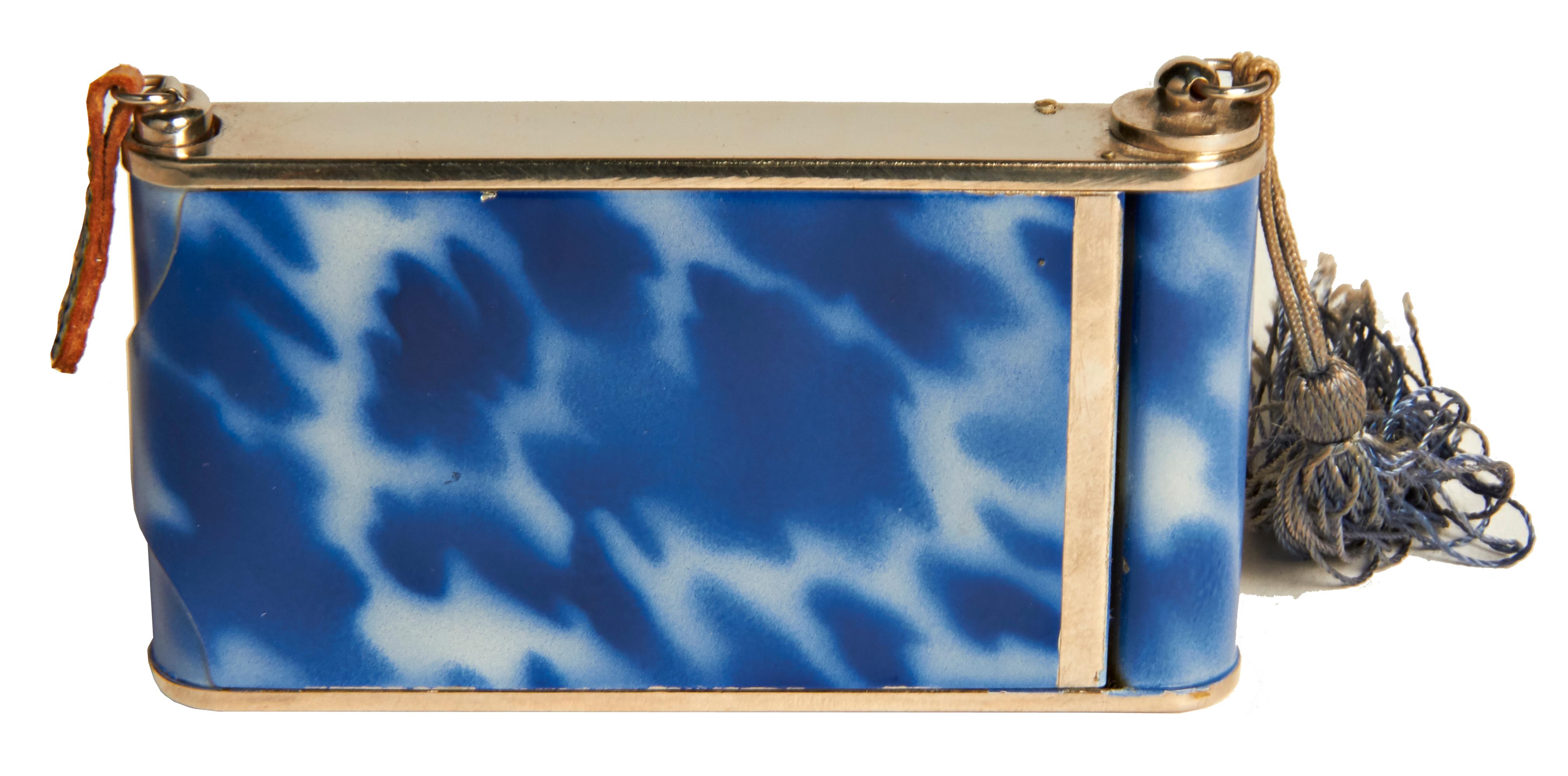 This beautifully designed German Art Deco camera compact/minaudiere features blue tortoiseshell enamel with a geometric design in ecru enamel and chrome. On one side it has a large lift-top compact with mirror in mint and unused condition and