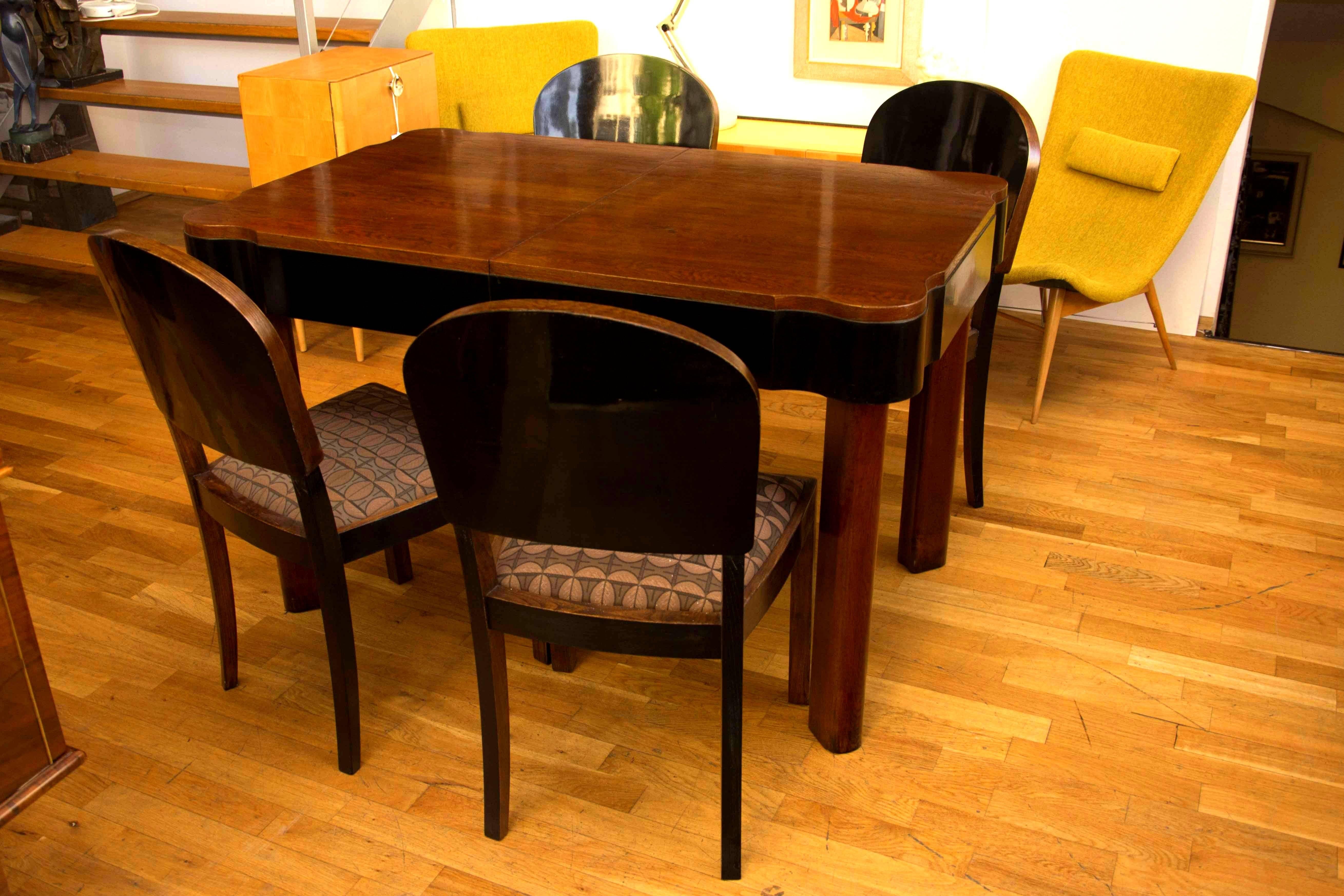 This very elegant dining set seats four people and features an adjustable oak dining table with four chairs. It has been made in Germany in the 1930s. The set has been professionally renovated; the wood has been polished to a high gloss using