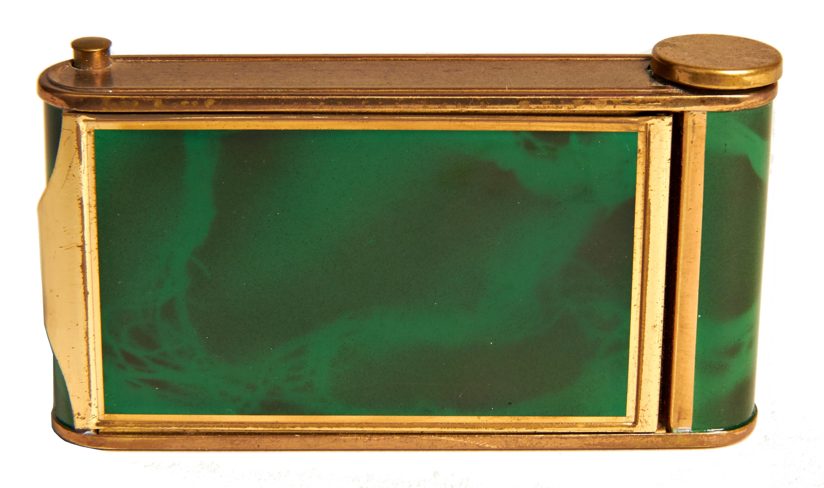 This rare geometric German Art Deco brass with green tortoiseshell enamel camera compact/minaudiere features on one side a push button powder compartment with original puff, a miniature Breitler Swiss music box and a pullout / pull-out lipstick