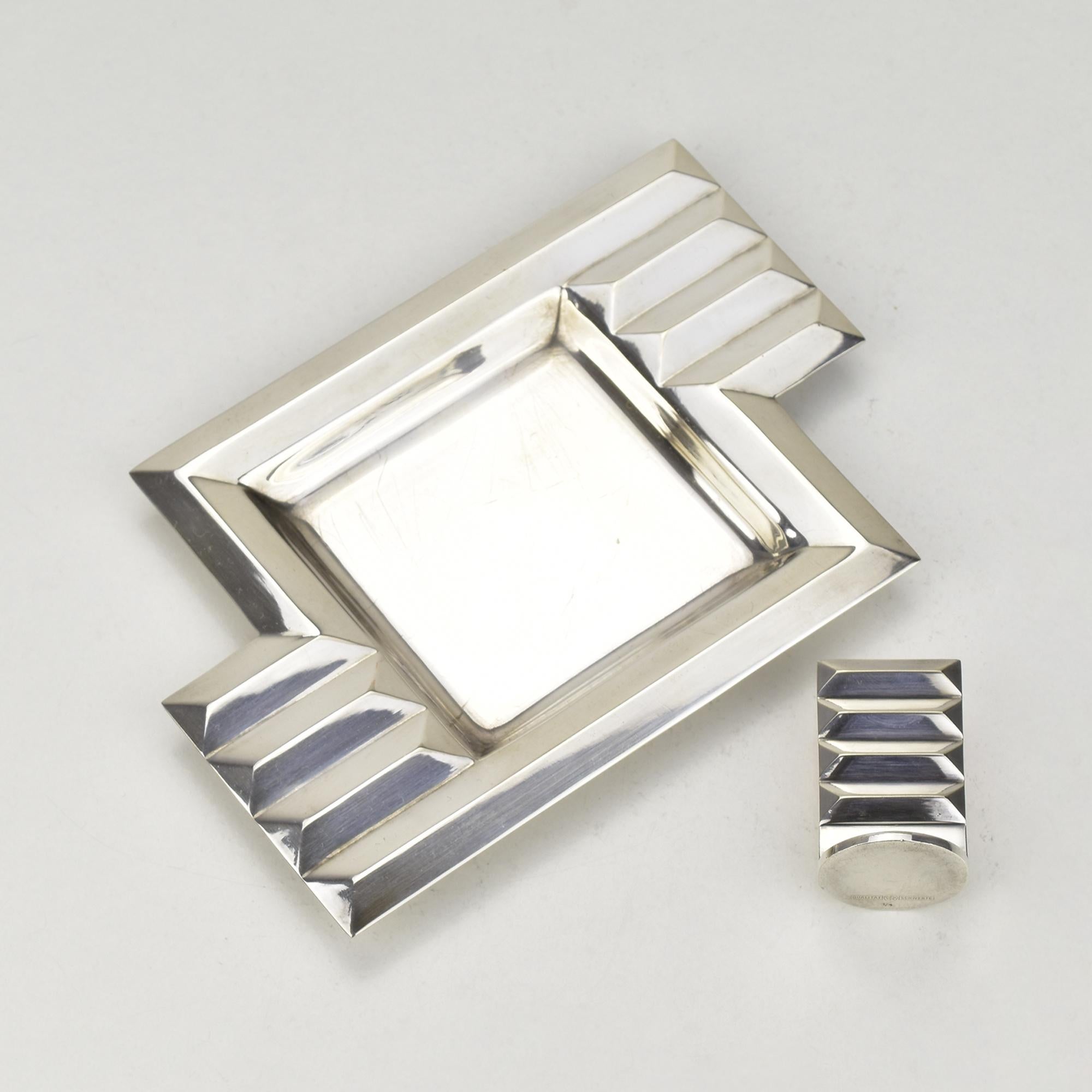 This striking silver-plated ashtray with the matching ember killer is a fine example of German Art Deco design, influenced by the Bauhaus movement. Crafted by the renowned manufacturer Schwerte, this piece features a geometric stepped design that