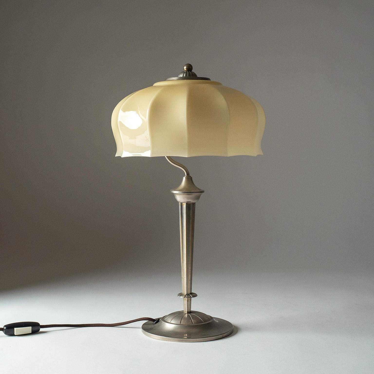 Lovely German Art Deco table lamp from the 1930s. Nicely detailed nickeled brass base with a delicate pale sand colored glass shade. Good original condition with some wear to the nickel plating. One original nickel and ceramic E27 socket with new