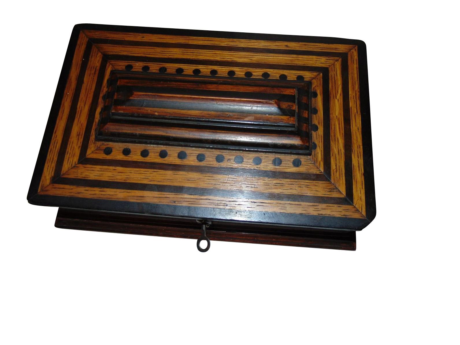 Petite and elegant wooden box or jewelry box from the German Art Deco period in the early 1930s. Made out of solid oakwood it convinces with a Classic design and Fine striped details of ebonized wood and inlay works. Features the original brass