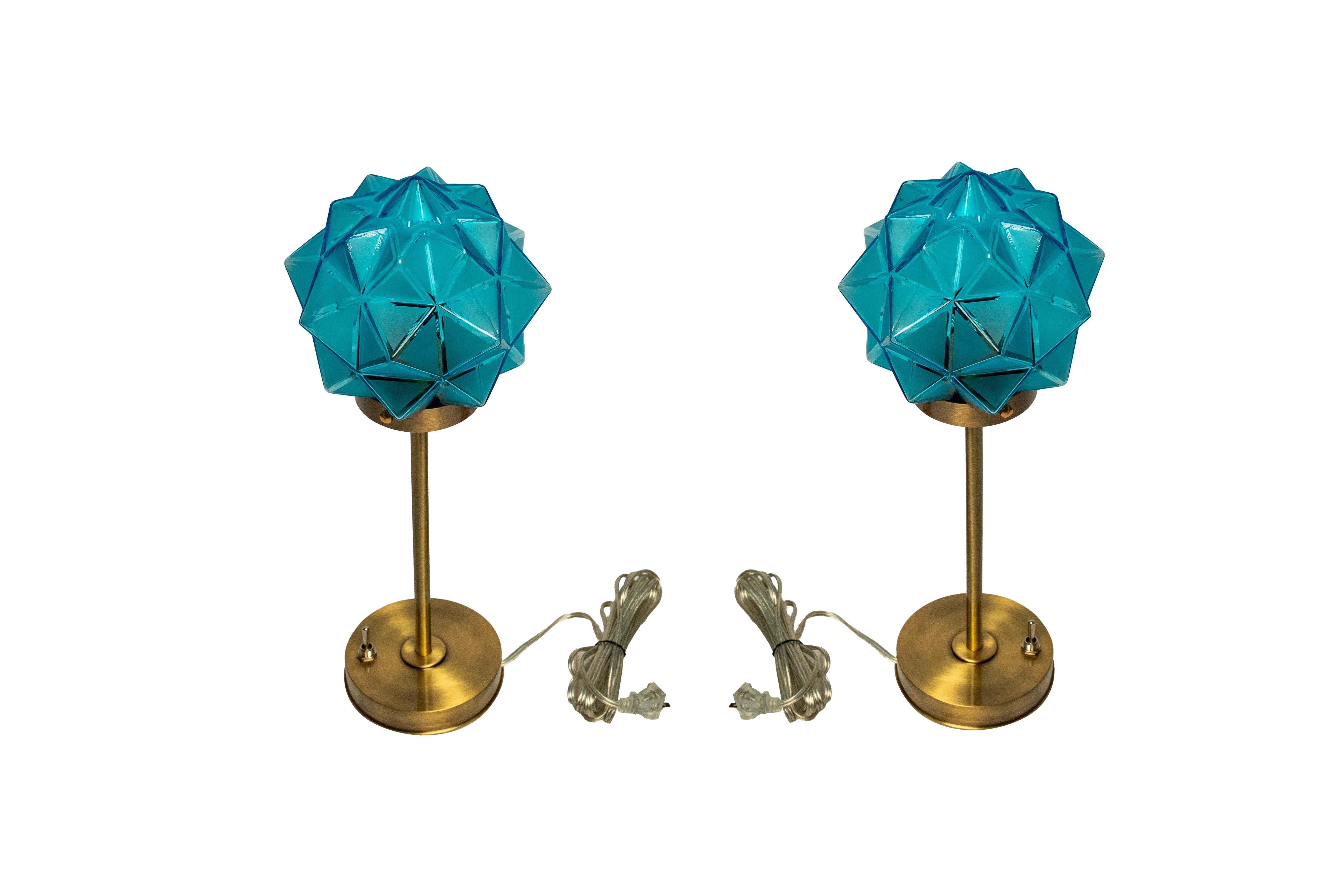A stunning and rare pair of Art Deco period art glass shades from Germany, mounted on slender brass stem table lamps.  Unusual blue color and rare star shape.  Bases newer than the shades.  Wired for American use with a standard base bulb.  Shade is