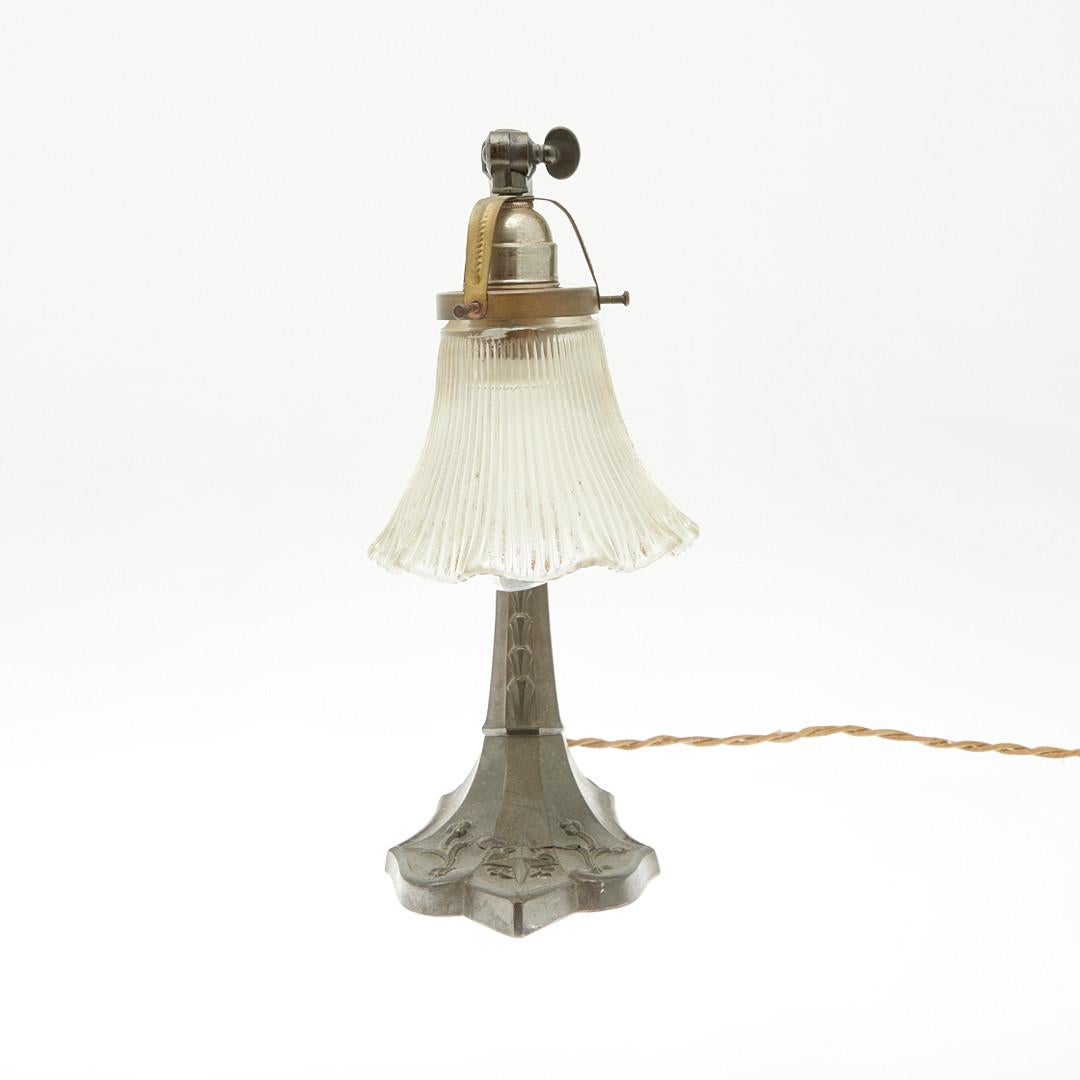 Lamp / table lamp, metal, glass. Metal construction with a curved lamp arm and a reliefed and wavy glass lampshade, as well as a florally decorated base and embossed 'F.R.C. Dep.', with a lamp
Age-appropriate signs of wear and rubbing, the