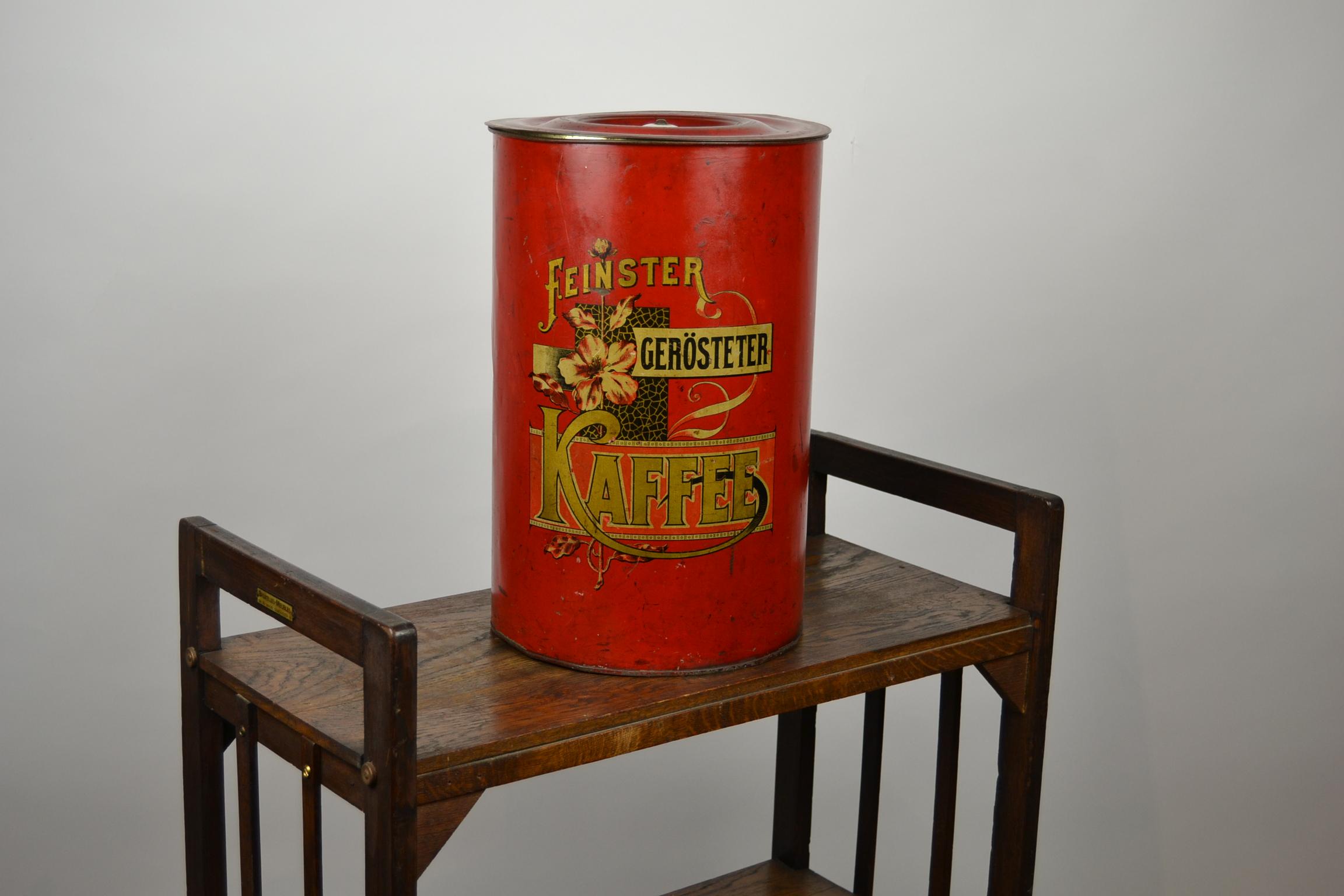 Art Nouveau - Jugendstil metal tube coffee box - coffee can - vintage coffee container - coffee bin . 
Red tole - Toleware - Tin Storage Box with 
lithographic design of flowers and gold lettering. 
The cover has also a porcelain knob. 
This