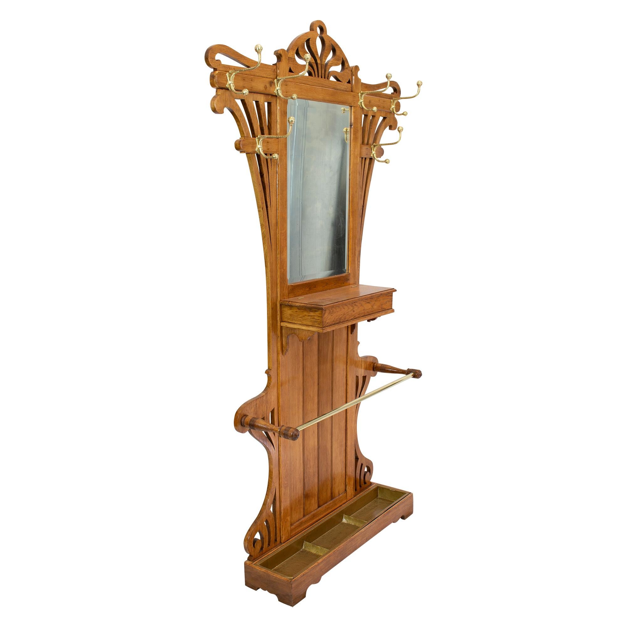 Very beautiful Art Nouveau wardrobe in oakwood with solid brass hooks. The wardrobe has a big umbrella stand as well as six clothes hooks. The wardrobe is from the time around 1900 from Germany. The mirror is facetted.