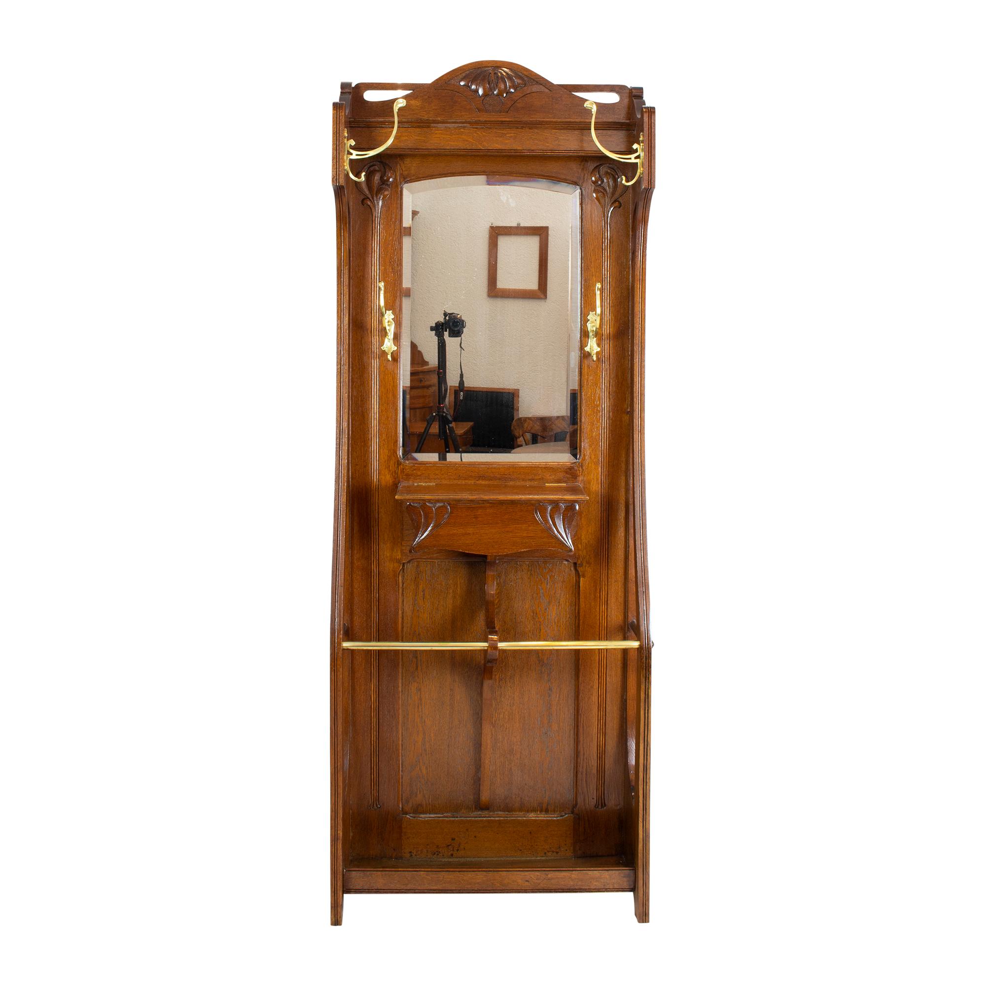 Very beautiful Art Nouveau wardrobe in oakwood with solid brass hooks. The wardrobe has a big umbrella stand as well as four massiv brass clothes hooks. In the center there is a shelf under which there is a compartment to open. The wardrobe is from