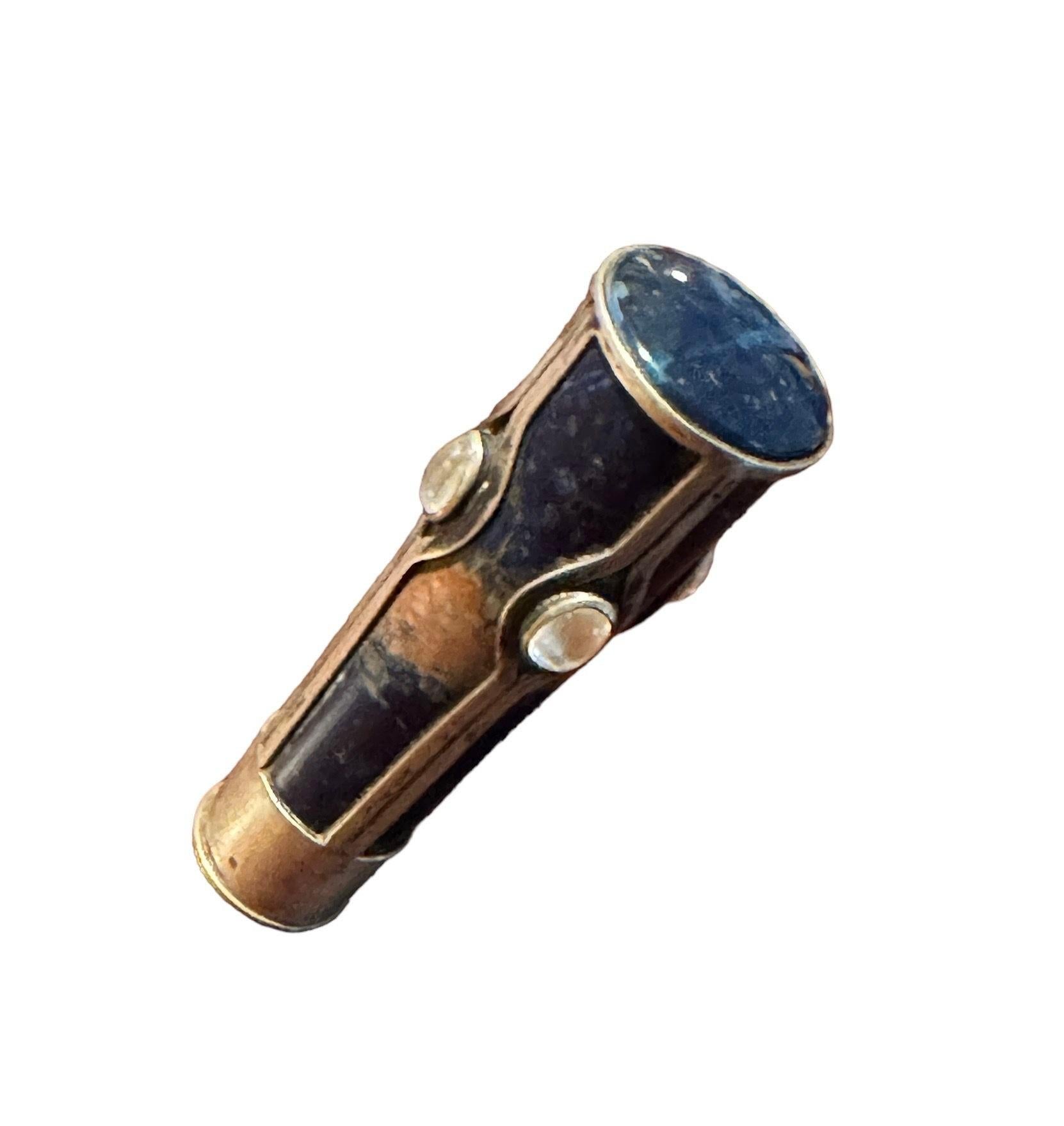 La pietra dura blu e color ruggine è montata in gabbia d'argento con 4 pietre lunari ovali e il sigillo 