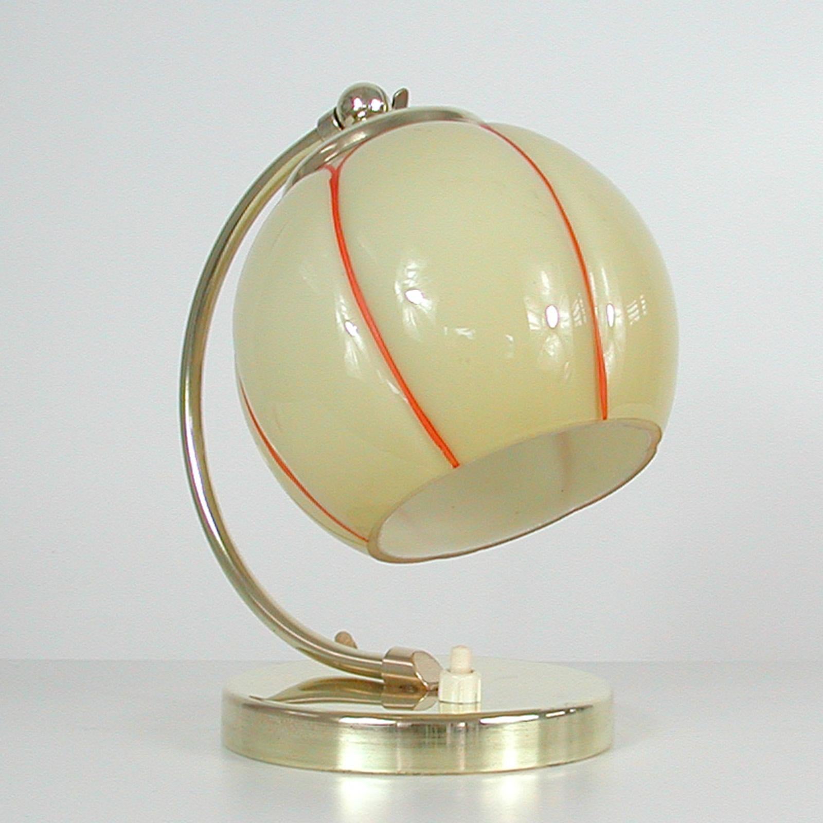 This pretty vintage table or bedside lamp was made in Germany in the 1930s during the Bauhaus period. It is made of brass and has got an adjustable lamp shade made of opaline glass.

Rewired with new silk cord and ready for use in any country of