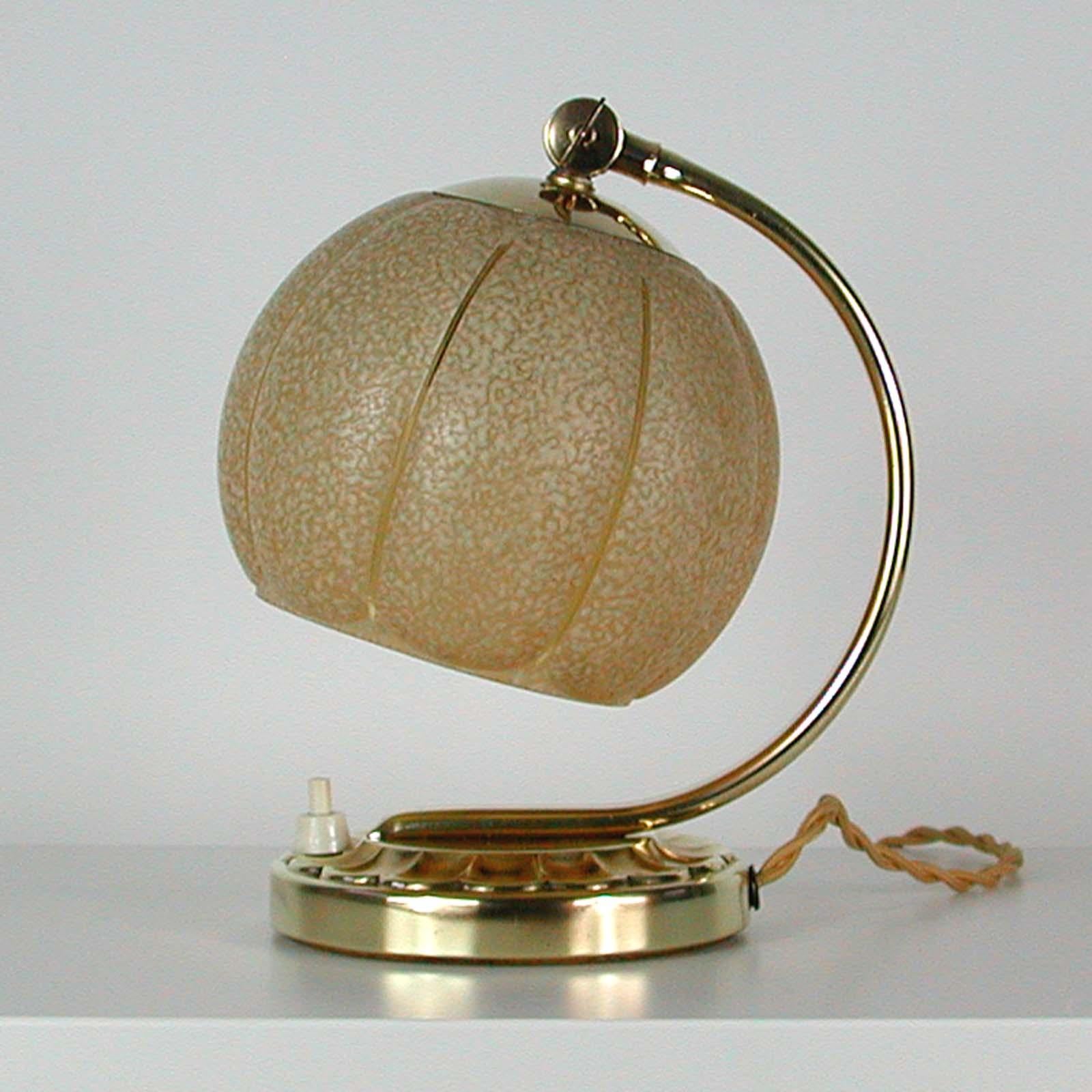 This pretty vintage table or bedside lamp was made in Germany in the 1930s during the Bauhaus period. It is made of brass and has got an adjustable lamp shade made of cream colored textured glass.

Marked DRGM (Deutsches Reich Gebrauchs Muster: