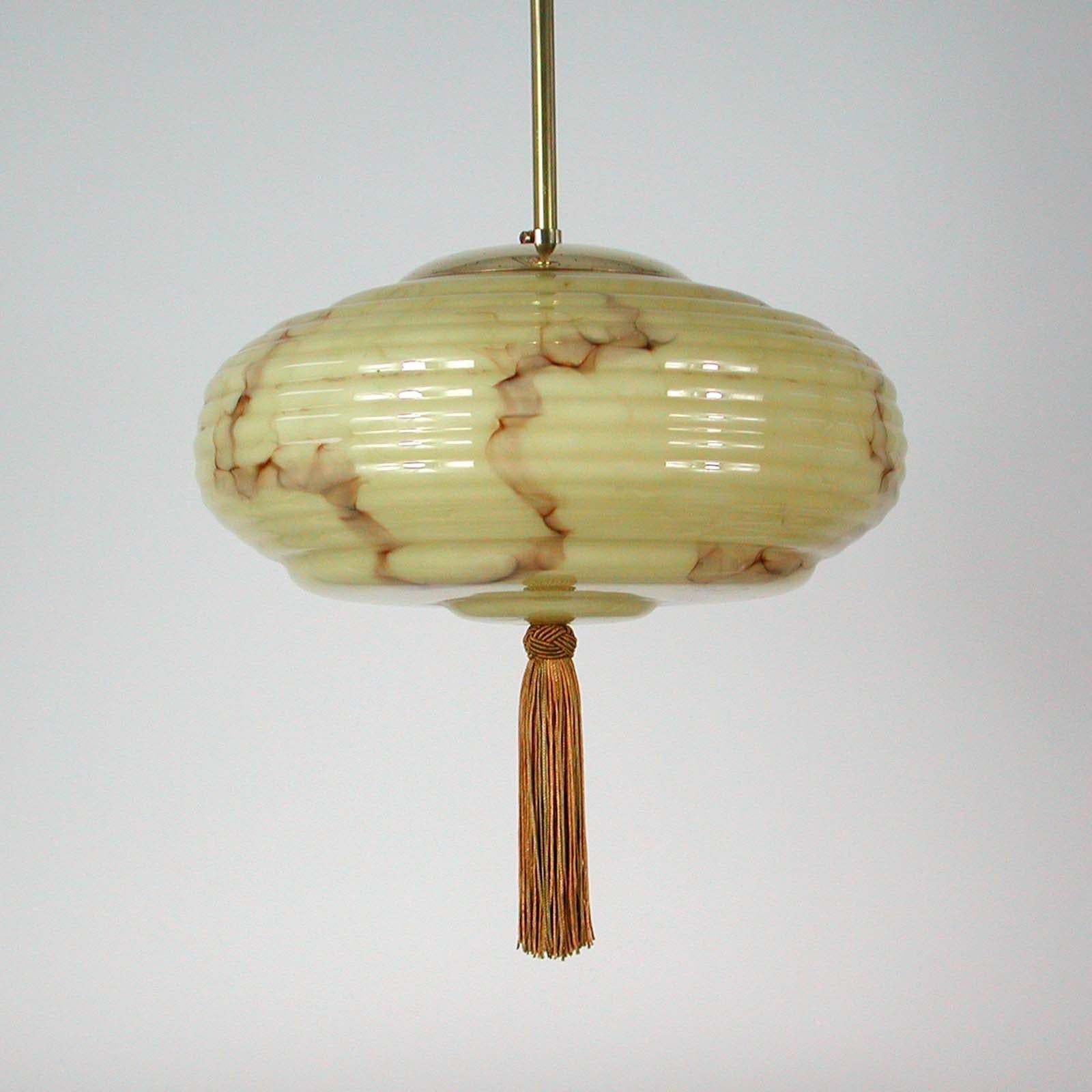 This elegant German pendant was designed and manufactured in Germany in the 1920s-1930s. The light is made of brass and has got a cream colored opaline marbled glass shade in typical Bauhaus Design. Good vintage condition with one E27 socket.

The