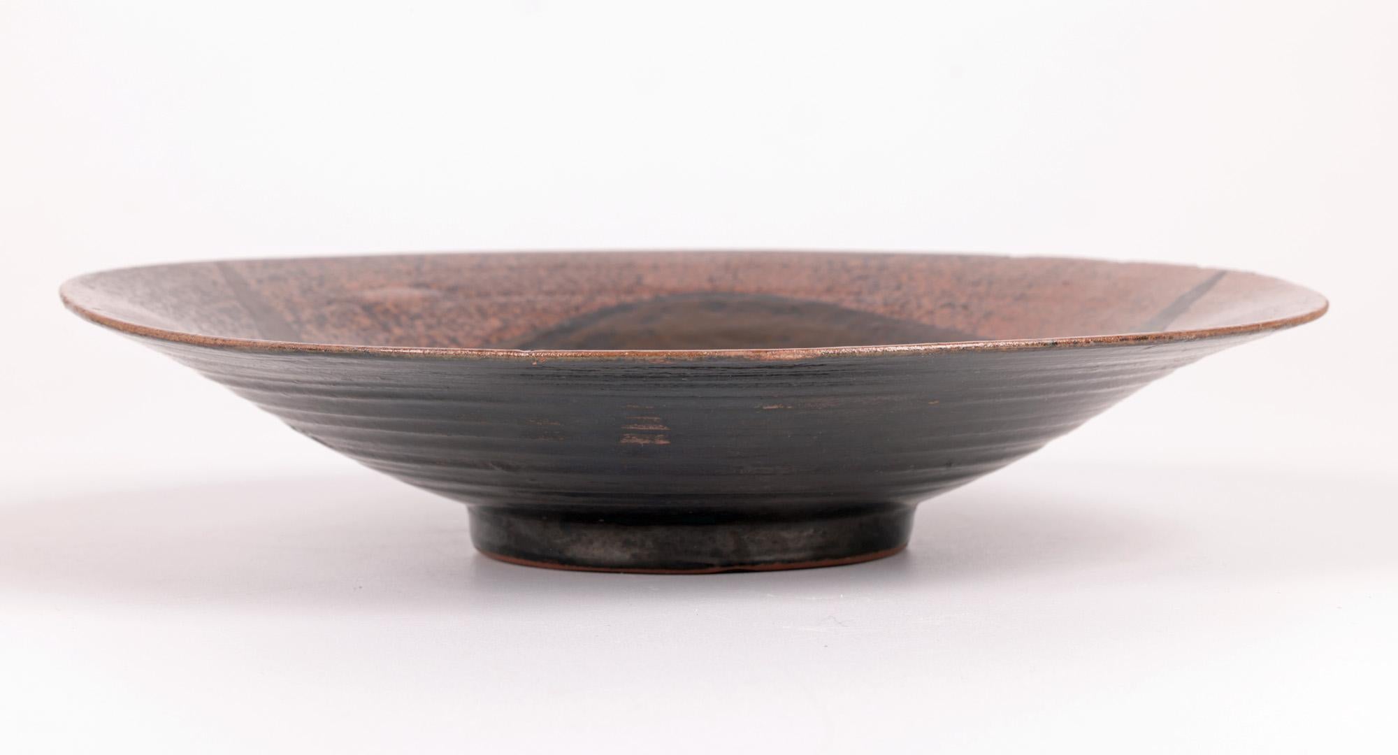 An unusual and very stylish German Bauhaus attributed ceramic glazed bowl or plaque made between 1930 and 1950. The bowl is lightly hand crafted in a red terracotta earthenware and stands raised on a narrow round foot with a splayed wide round