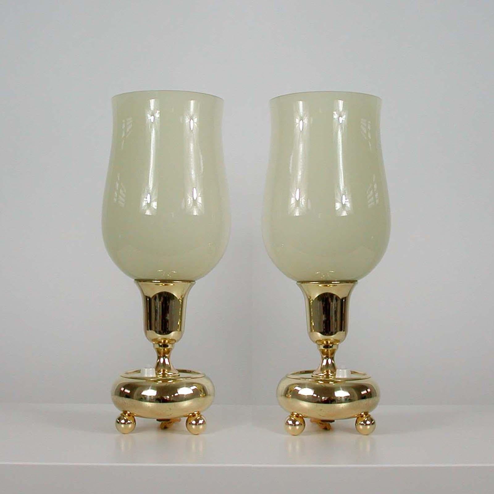 These table or bedside lamps were designed and manufactured in Germany in the 1930s during the Bauhaus period. They are made of brass and have got cream colored opaline glass lamp shades.

Both lamps have been re-electrified and rewired with new