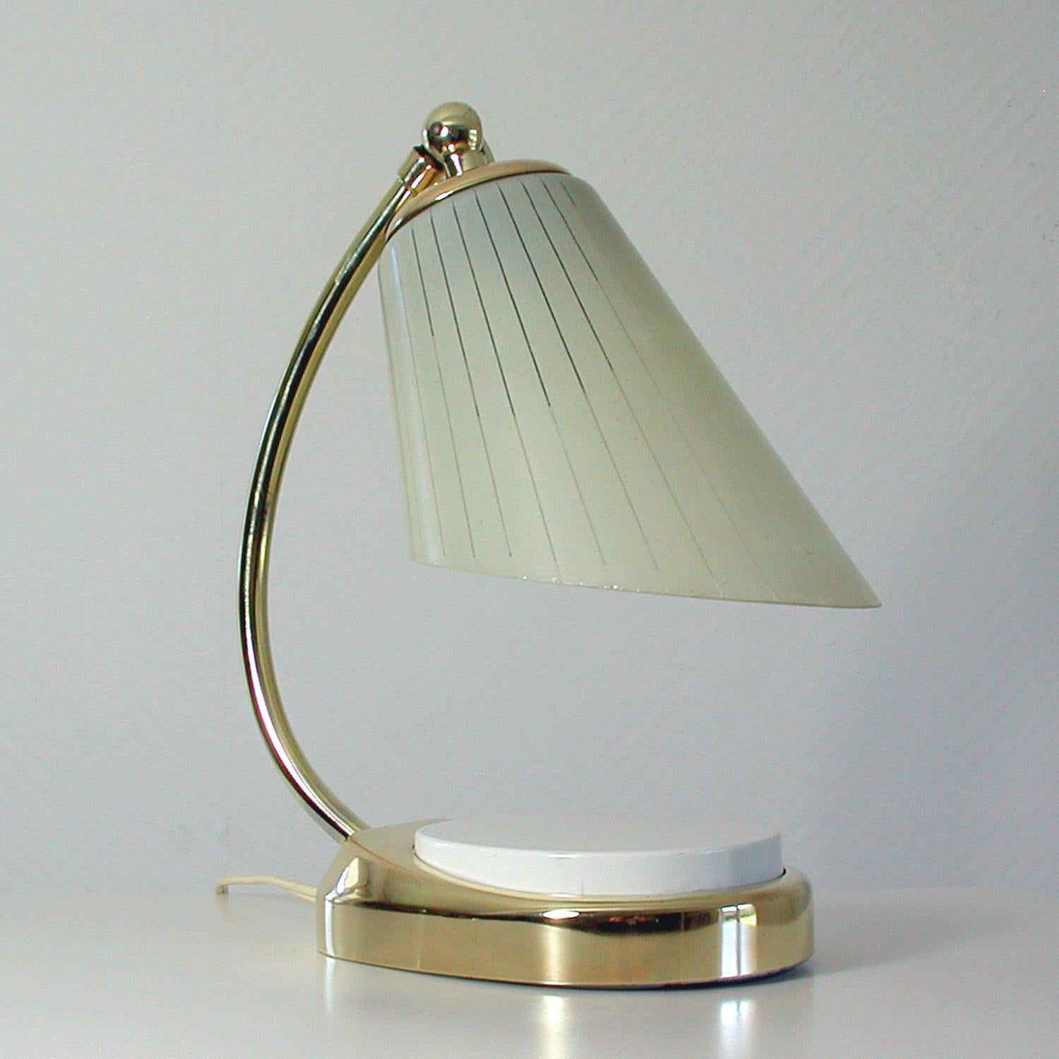 The predecessor of this vintage table light was designed by Marianne Brandt during the Bauhaus period 19 the 1930s and manufactured in Germany in the 1960s (gmf /mewa /ruppelwerke typ 7404). It has got a brass base, a brass lamp arm and an