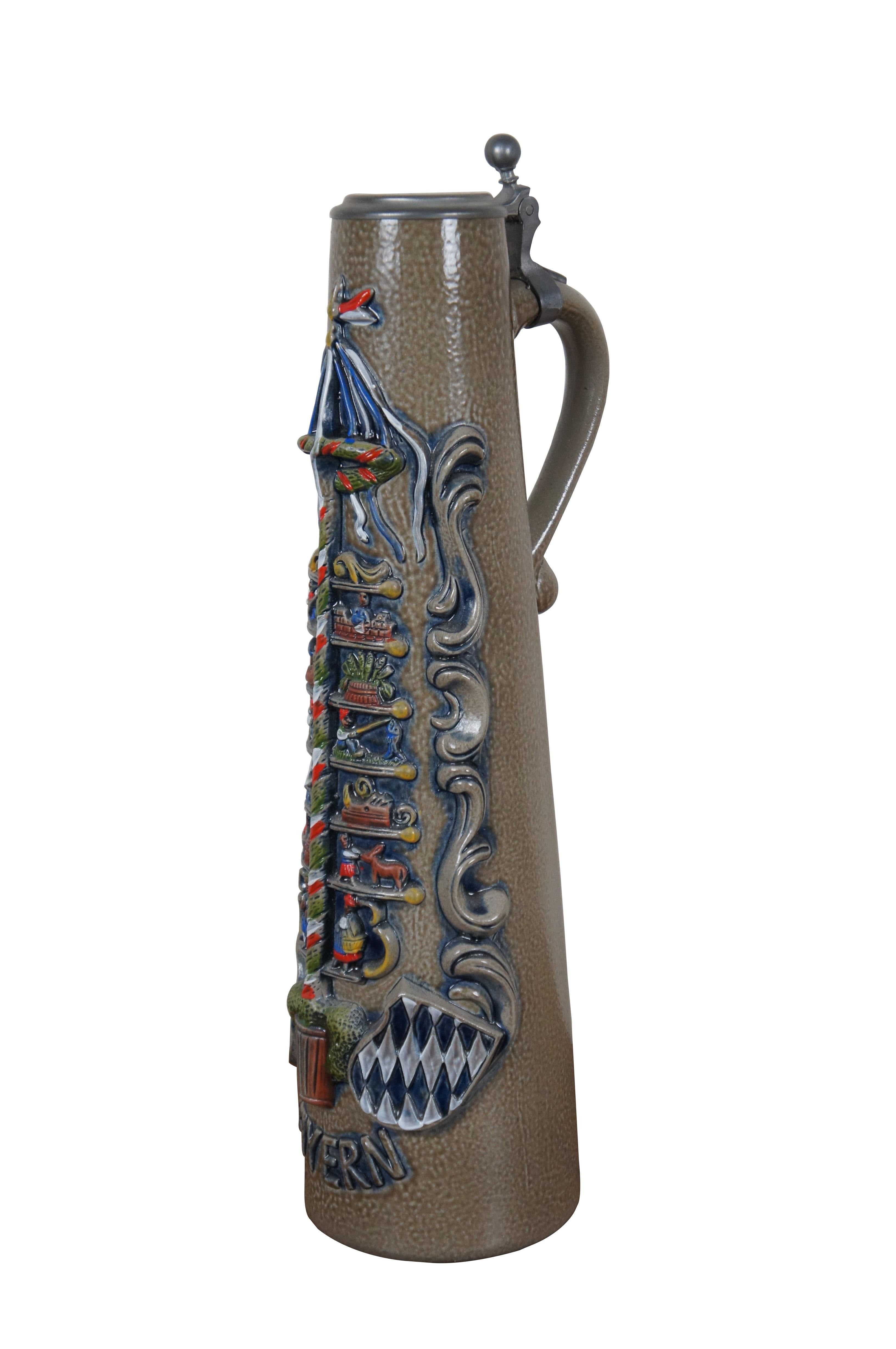 Stein di birra in gres della fine del XX secolo, originale King numero 906, molto alto, con lo stemma del Bayern sotto un palo di maggio affiancato da scene in miniatura. Coperchio di latta inciso per commemorare gli arbitri di calcio di Augsburg