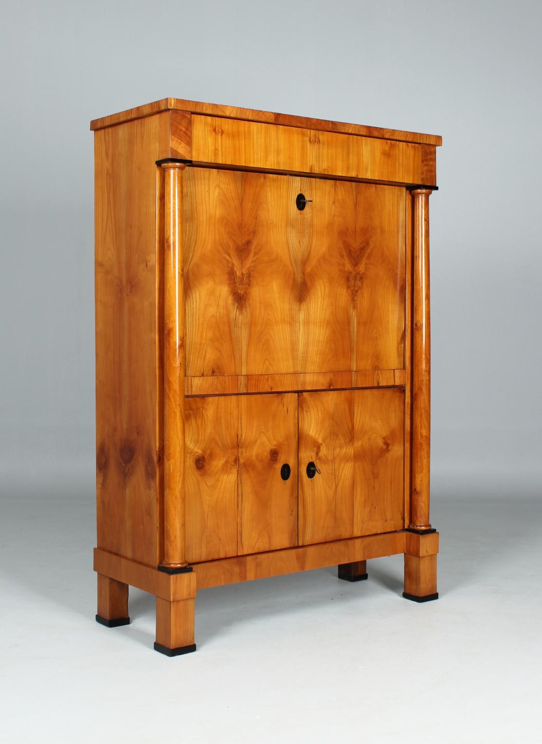 Biedermeier writing cabinet in cherry veneer with columns

Southwest Germany
Cherry tree
Biedermeier around 1820

Dimensions: H x W x D: 151 x 104 x 44 cm

Description:
Cubist secretaire standing on socketed square feet with set solid