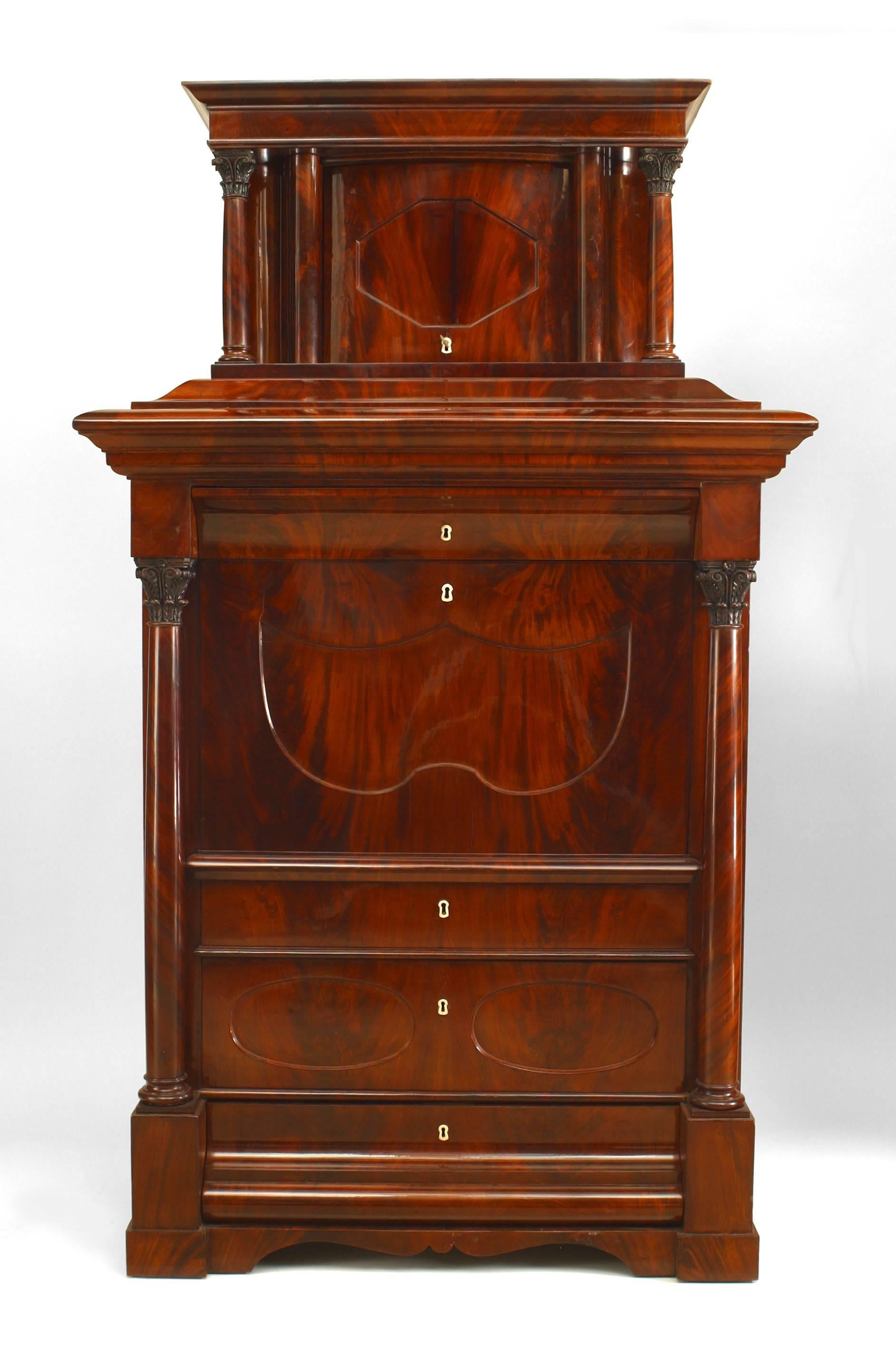 German Biedermeier (circa 1820) mahogany secretary cabinet with Corinthian columns on top and bottom section and a centered drop front revealing a series of drawers and columns
