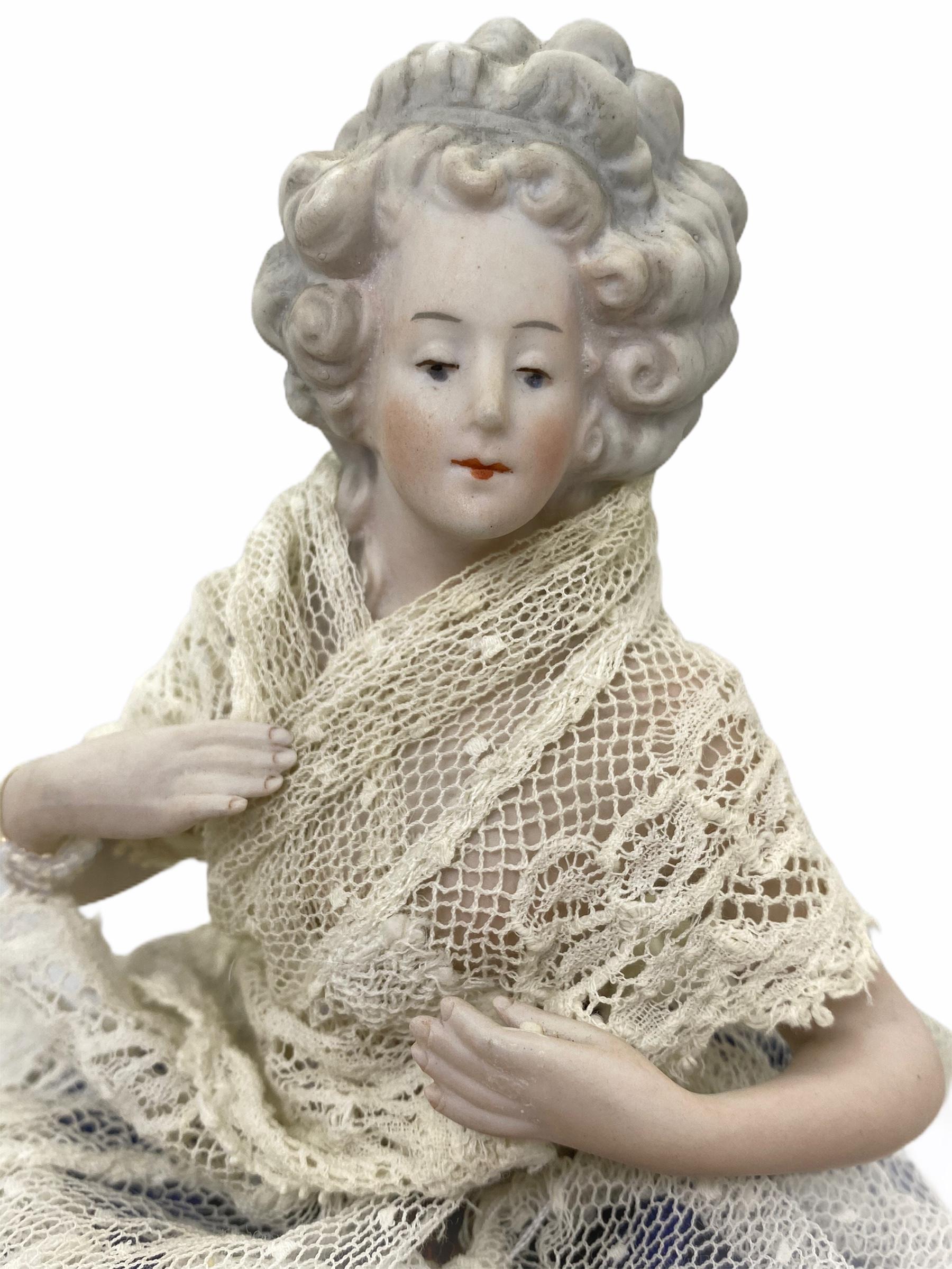 A petite antique German half doll with original lace dress on wire base.
She is holding the hand away. It is marked with mold number 7125/5.
It is in very good condition with no chips cracks or restorations.
