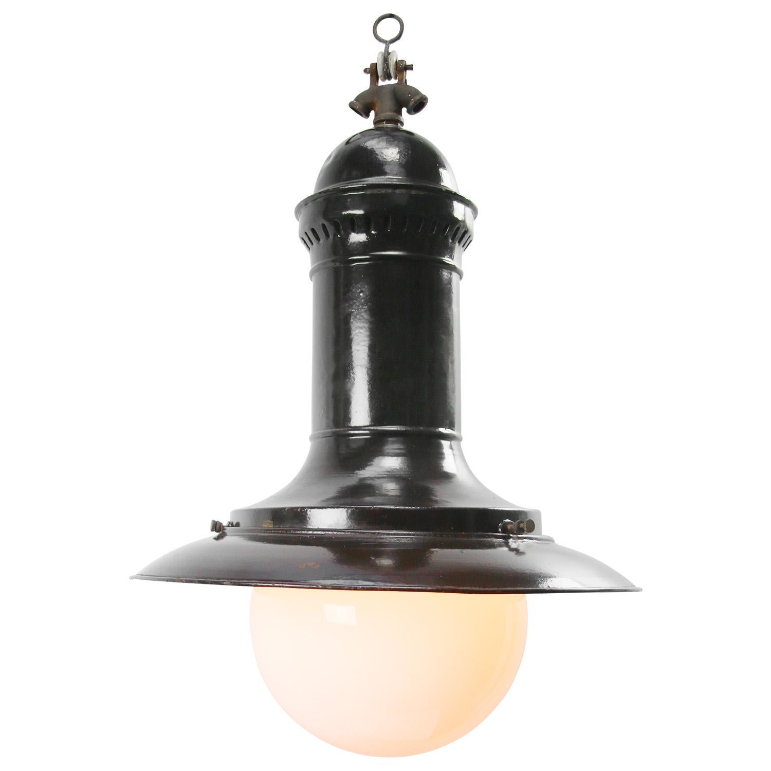 German, 1920s, black enamel factory pendant light.
White opaline glass. Cast iron top.

Measures: weight 3.20 kg / 7.1 lb

Priced per individual item. All lamps have been made suitable by international standards for incandescent light bulbs,