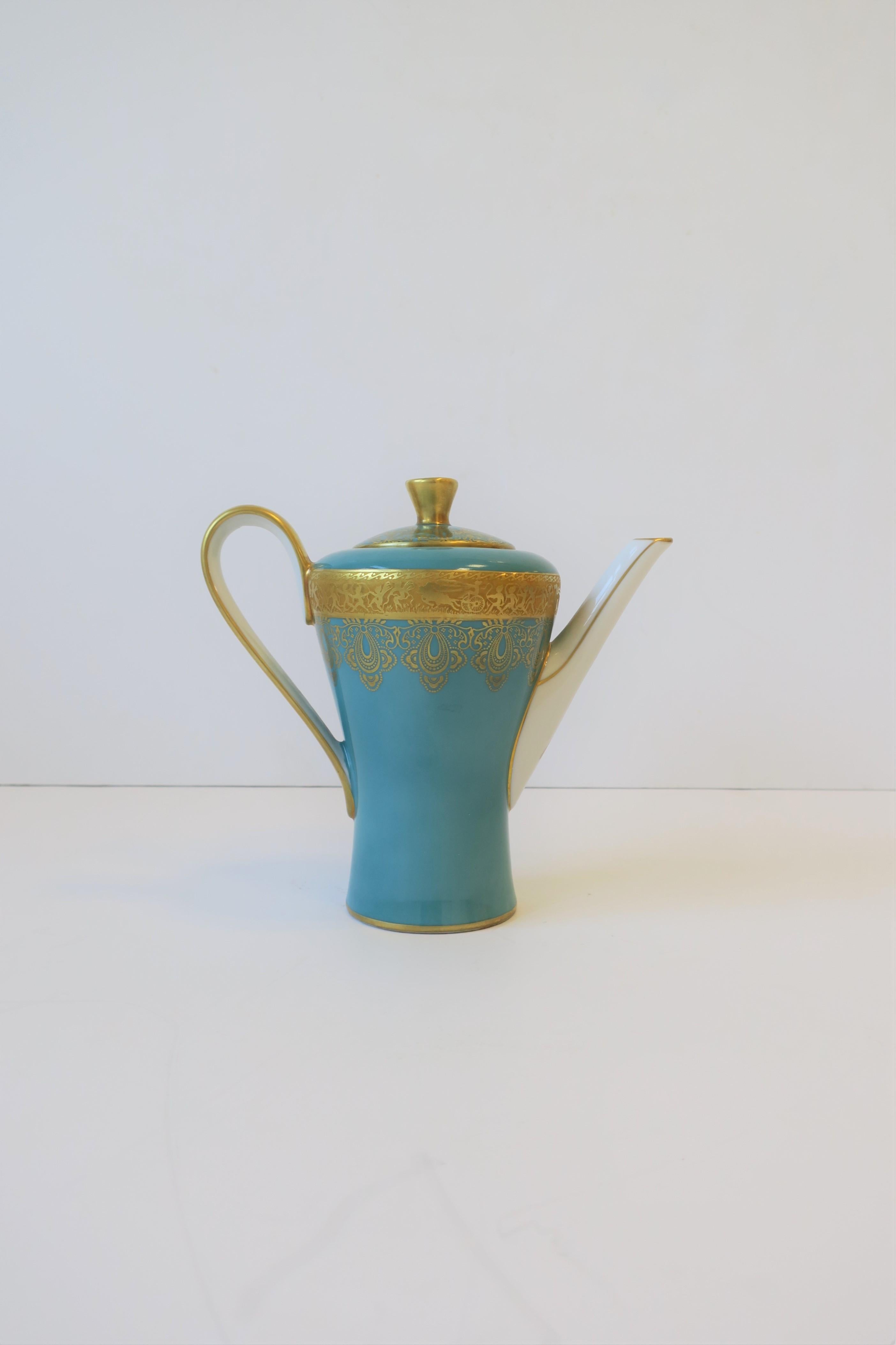 A beautiful German turquoise blue, gold and white porcelain tea or coffee pot, circa early to mid-20th century, Germany. Piece has a beautiful detailed raised 24-karat gold relief of horse and carriage, animals and fairies, around top exterior band.