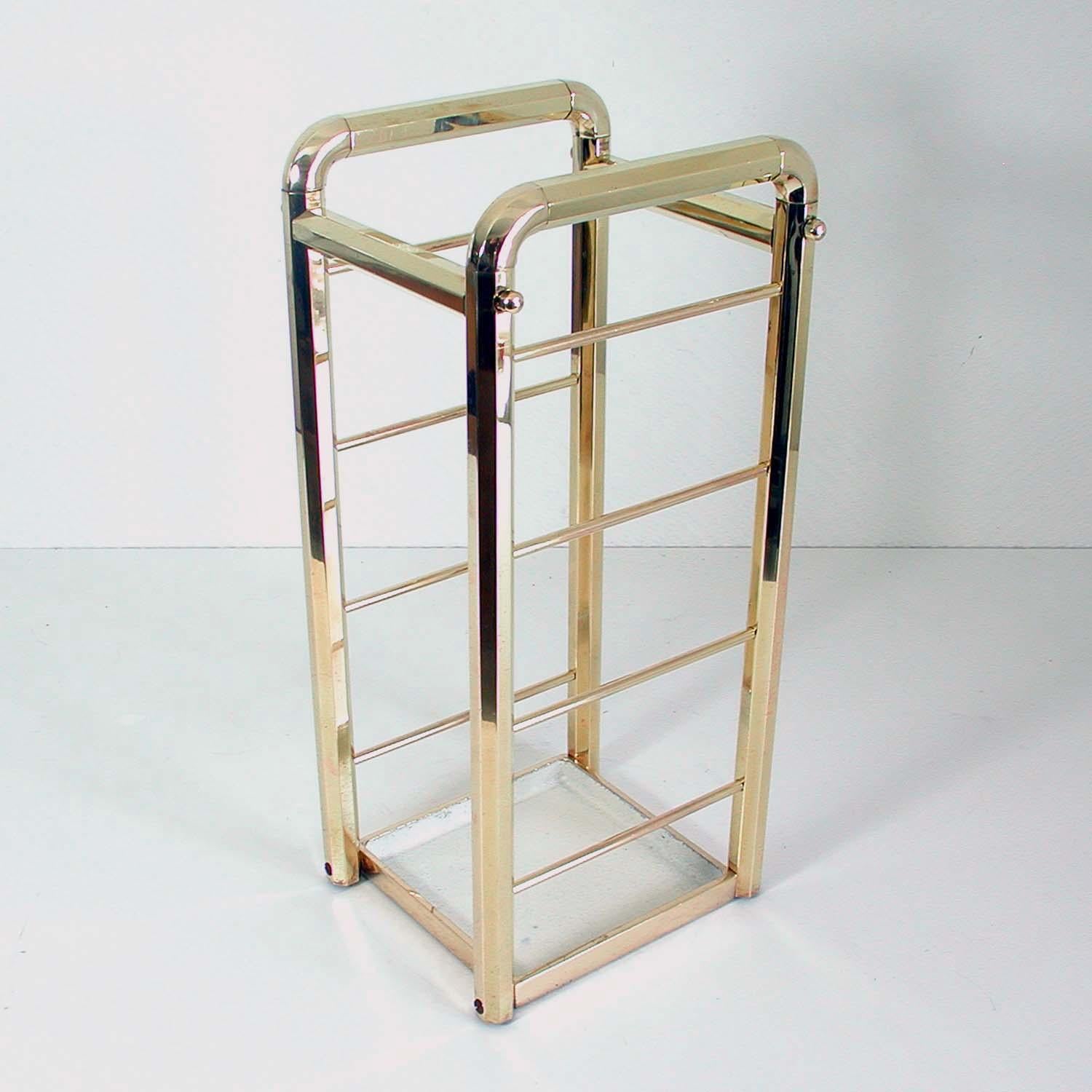 This vintage Art Deco umbrella stand was made in Germany in the 1930s-1940s in typical functional Bauhaus design. It is made of brass and has got a cream lacquered cast iron base.

There is some wear to the lacquered base as you may expect. The