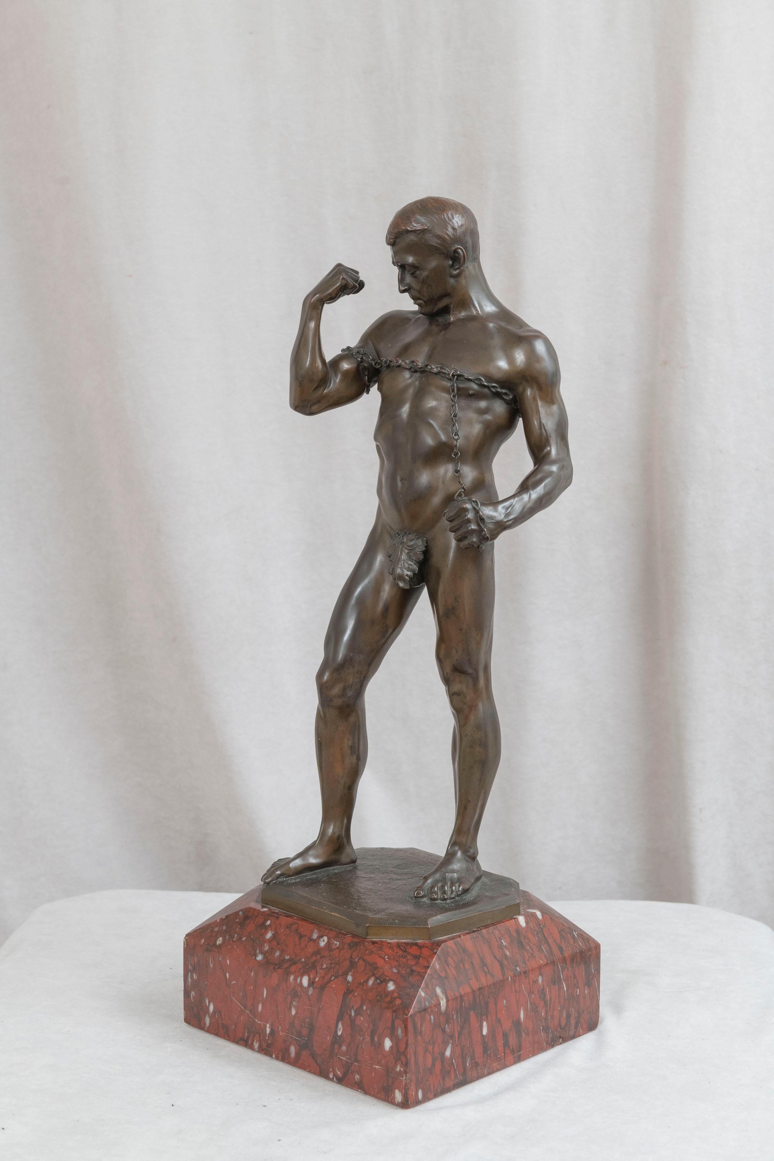 This powerful and handsome young man is going to break out of his chains. Showing great strength and muscularity, coupled with a beautiful factory brown patina, and mounted on a red rouge marble base all come together to make this an exceptional