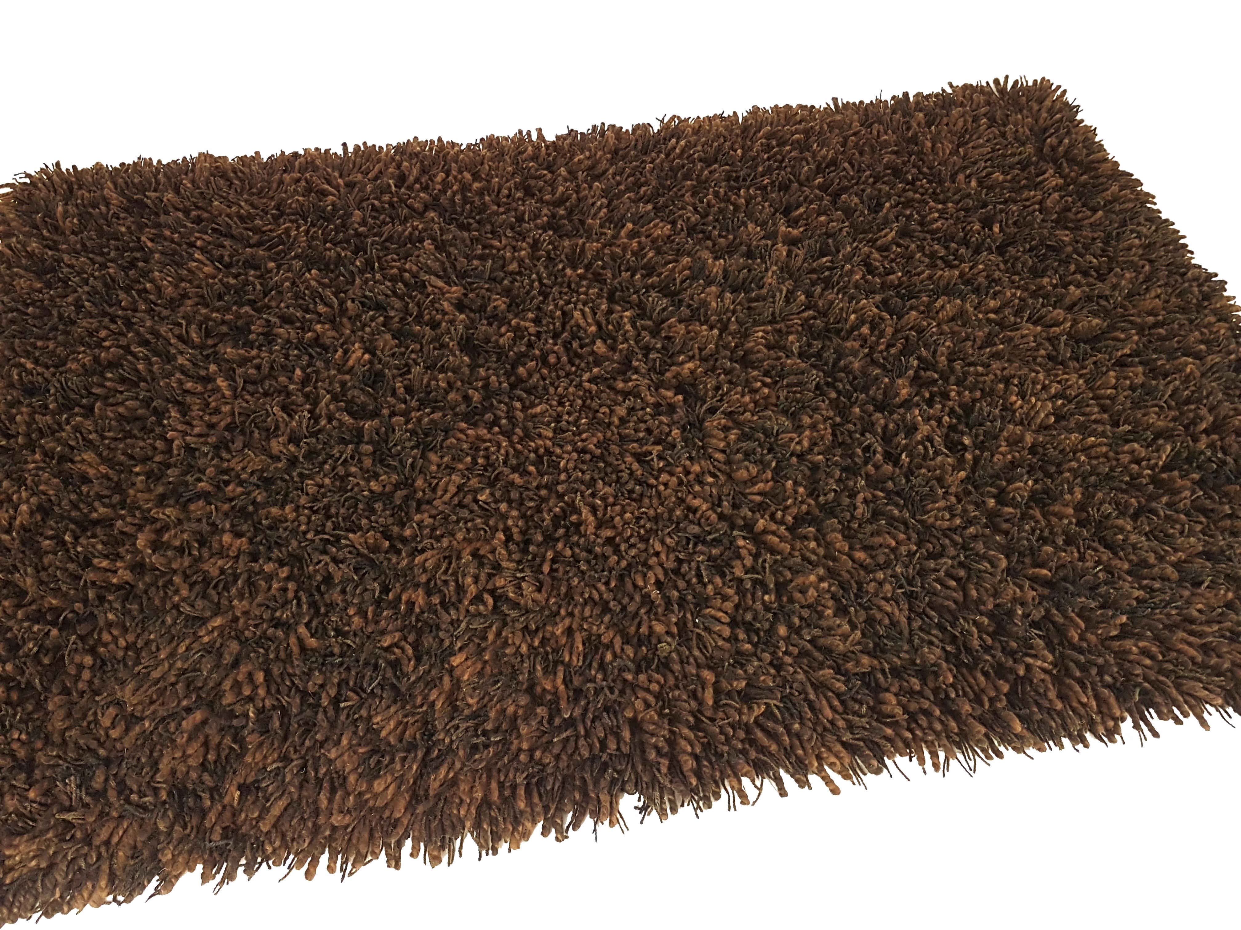 This vintage carpet was produced in Germany, circa 1970s. It is made from 100% wool in several shades of brown. The carpet remains in perfect condition: it has never been used (it comes from a 1970s furnishing store remaining).