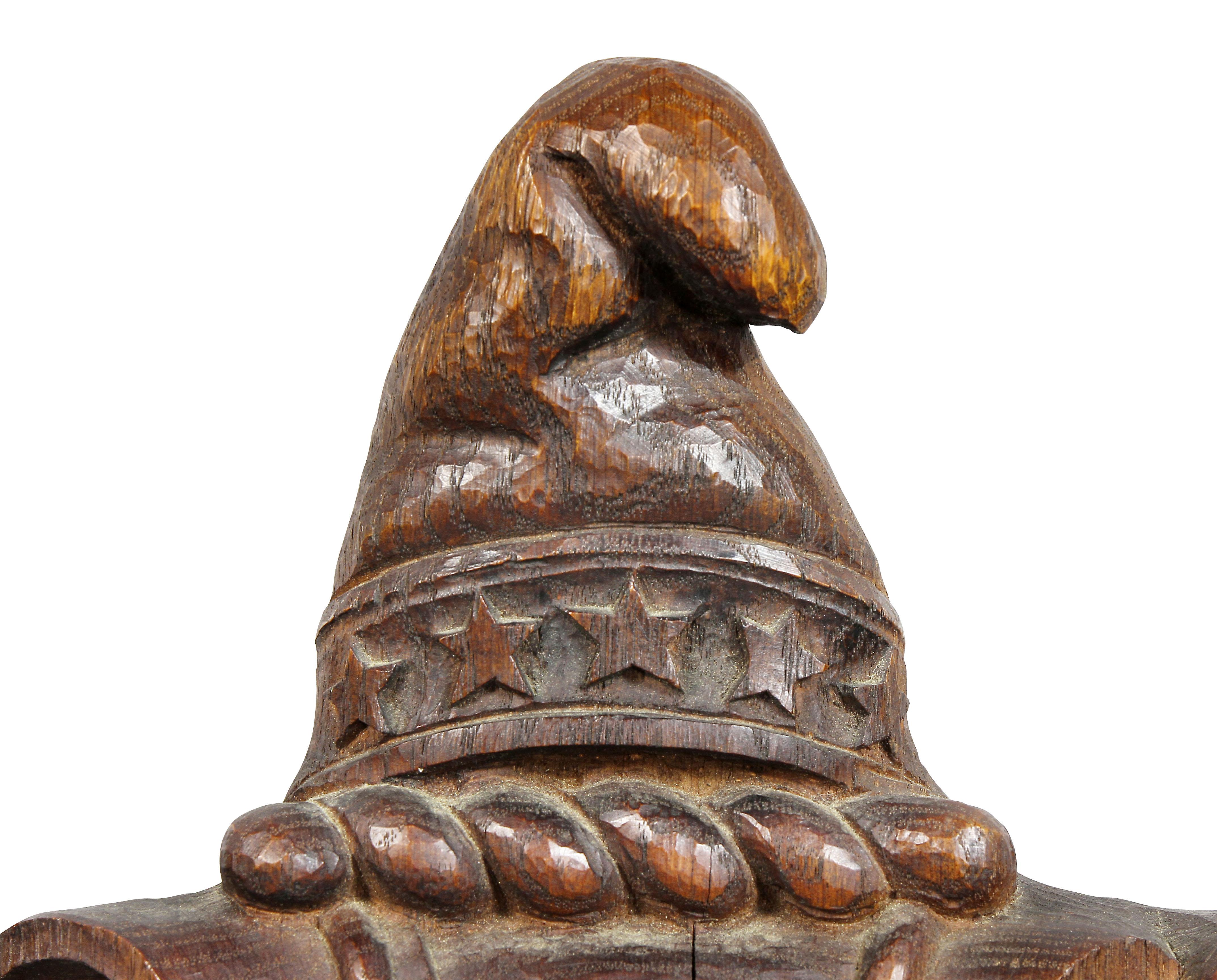 With a beaver and a phoenix bird and central cap over a shield and coat of arms, shaped ribbon scrolled base.