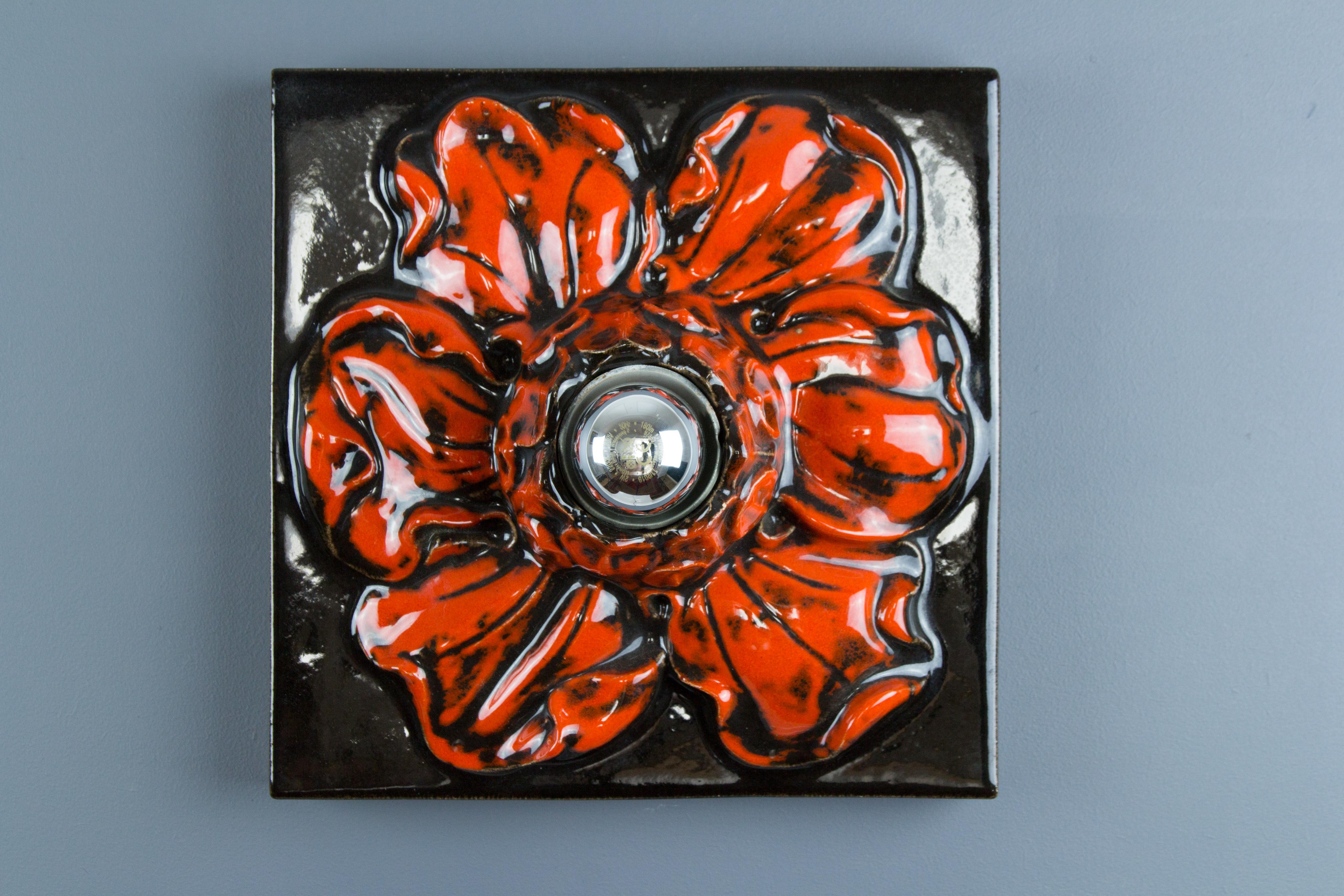 Beautiful ceramic square red wall lamp in the shape of a flower, made in Germany, in the 1960s. The mirror top light bulb is giving it a stunning light effect. The flower-shaped lamp can be used as a wall or table lamp or ceiling light fixture. One