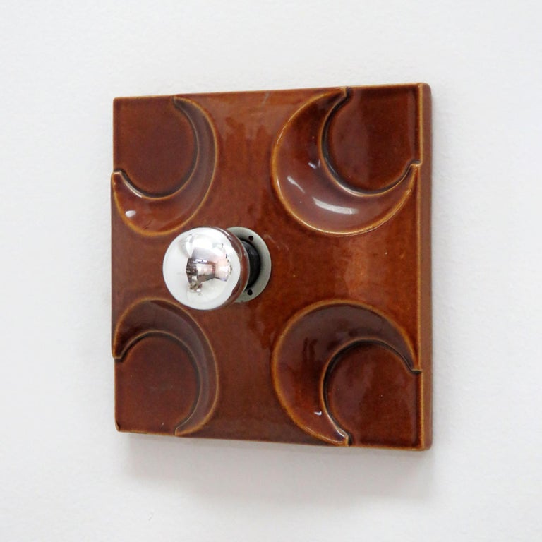 Wonderful geometric ceramic wall lights, 1960, with red-brown glaze. Single bulb wall lights/flush mounts shown with a mirror tip bulb that casts a wonderful shadow play against the wall. Wired for US standards, one E12 socket per fixture, max.