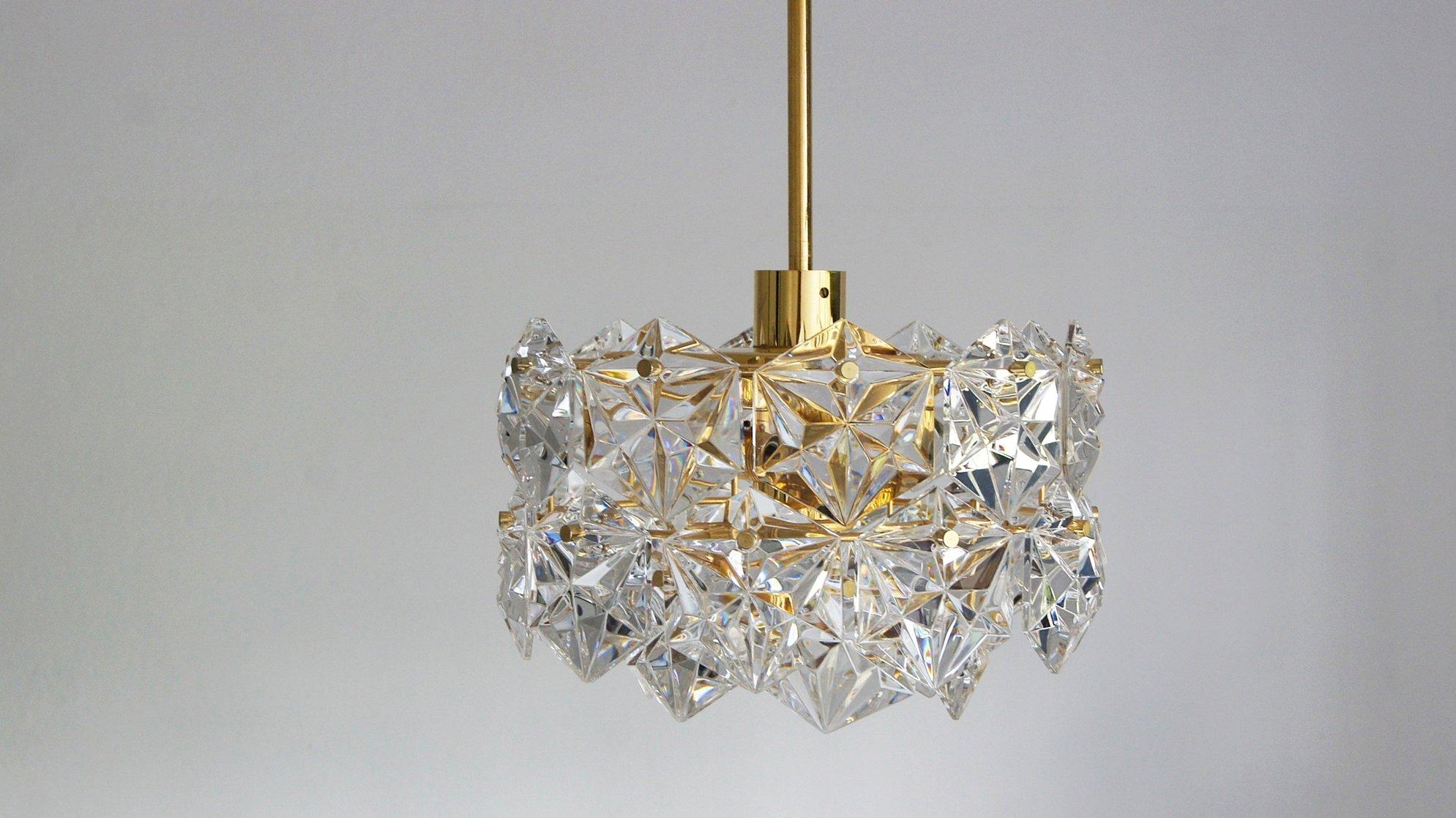 Beautiful large and original mid century chandelier by Kinkeldey from the Royal Kristall series. 2 tier chandelier with brass frame. Individual circles decorated with crystals.
Equipped with 3 E14 bulbs and one main bulb that radiates in the central