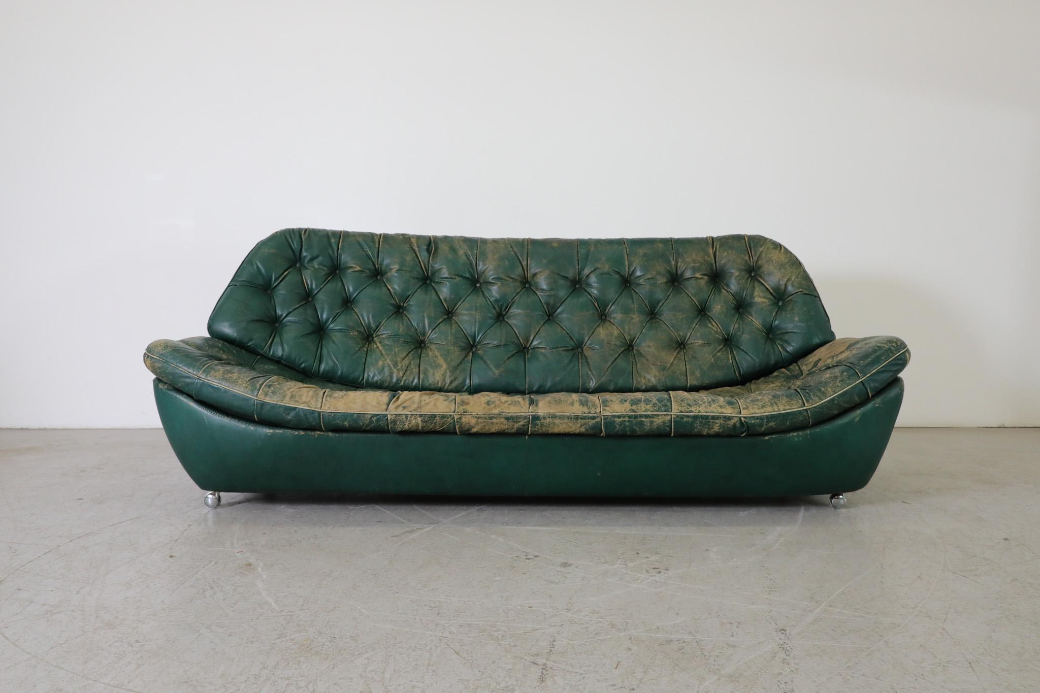 Vintage Artifort style green tufted leather sofa. A Mid-Century Chesterfield! 
Green leather frame with matching tufted leather back and seat cushions on chrome wheels and short chrome feet with rounded wood tips. This well loved three seater sofa