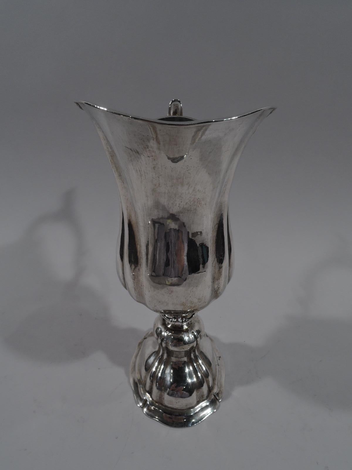 German classical silver ewer, 18th century Lobed baluster bowl with helmet mouth and leaf-capped double-scroll; screwed onto short flanged support on lobed and double-domed oval foot. Fluid and graceful form. Marks include Aubsburg city stamp.